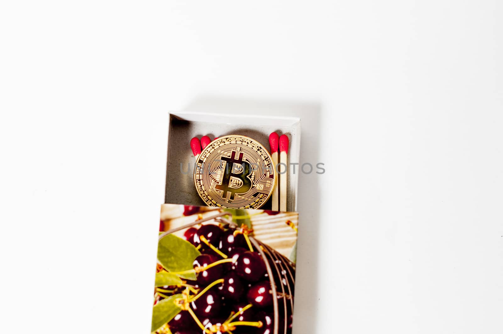 bitcoin electronic coin inside a matchbox white background