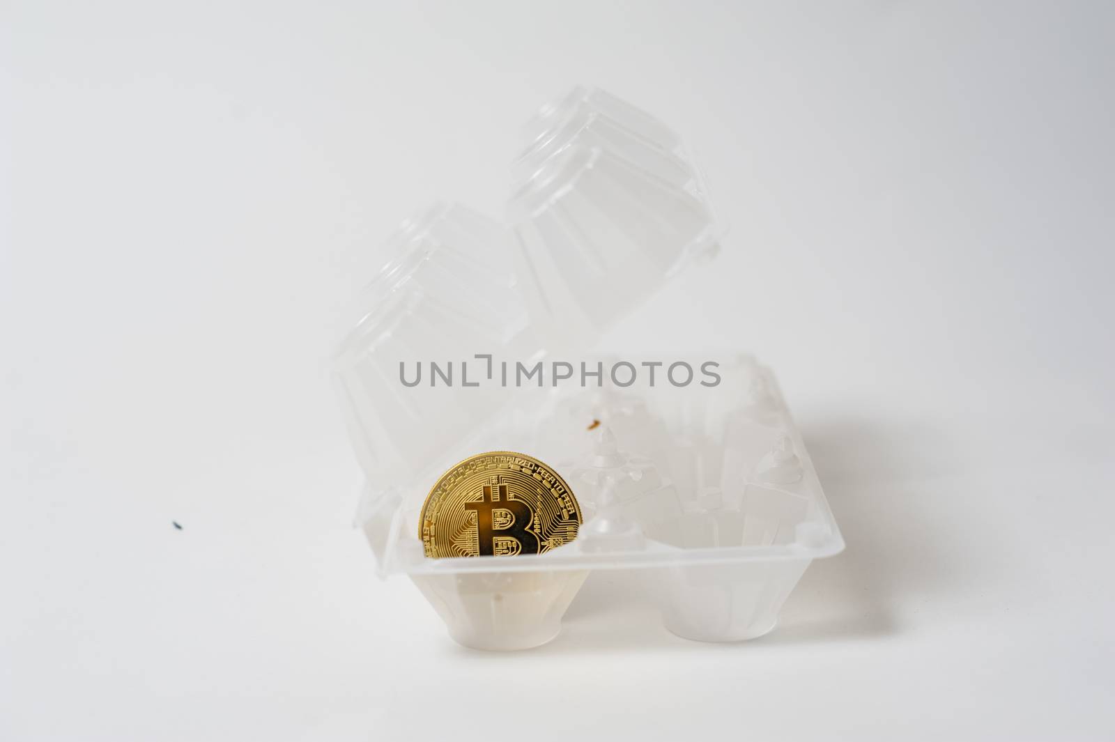 bitcoin electronic coin inside an egg holder, white background