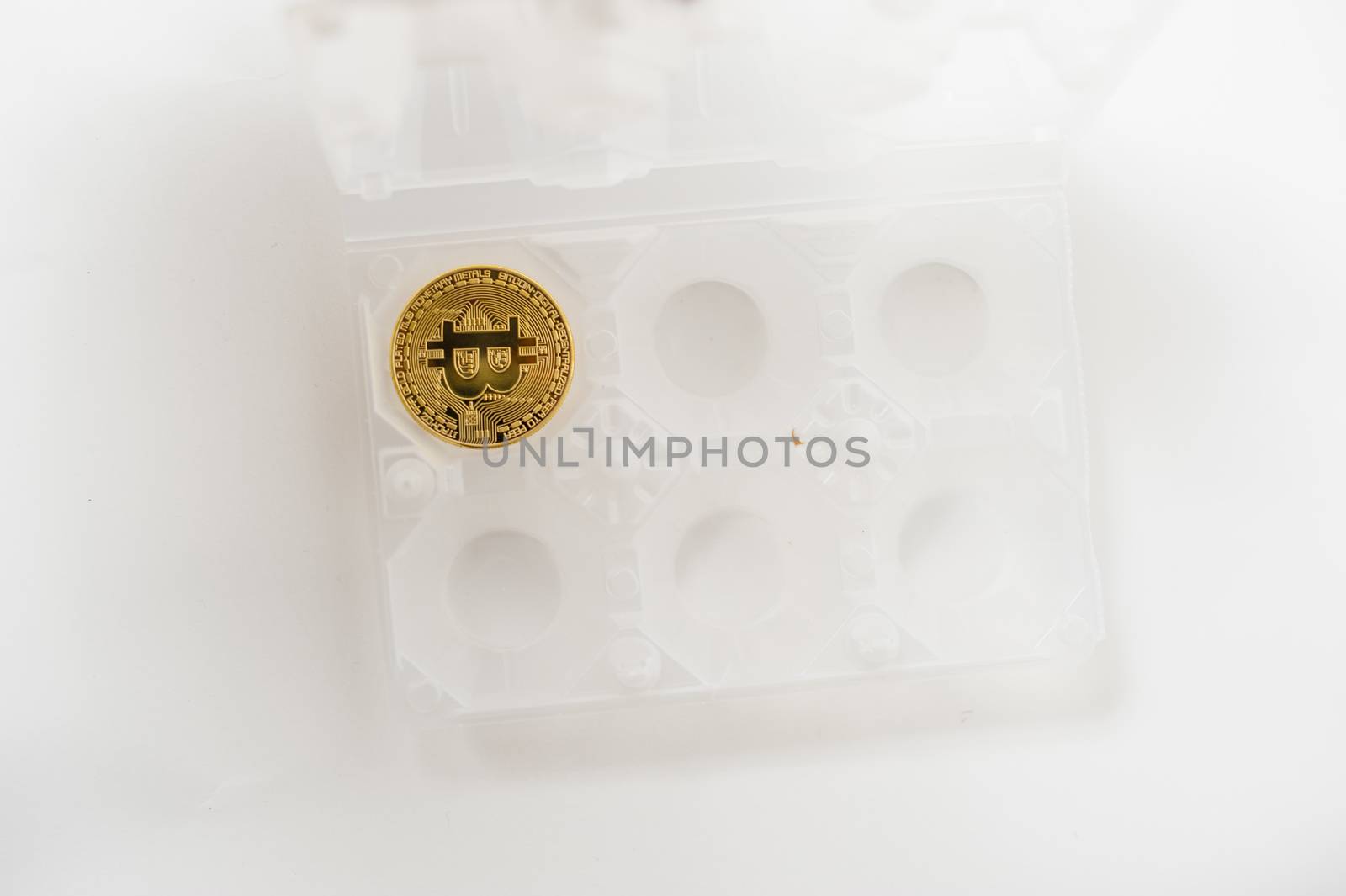 bitcoin electronic coin inside an egg holder, white background