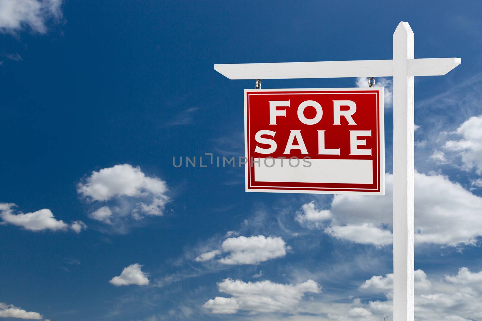 Left Facing For Sale Real Estate Sign Over Blue Sky and Clouds With Room For Your Text.