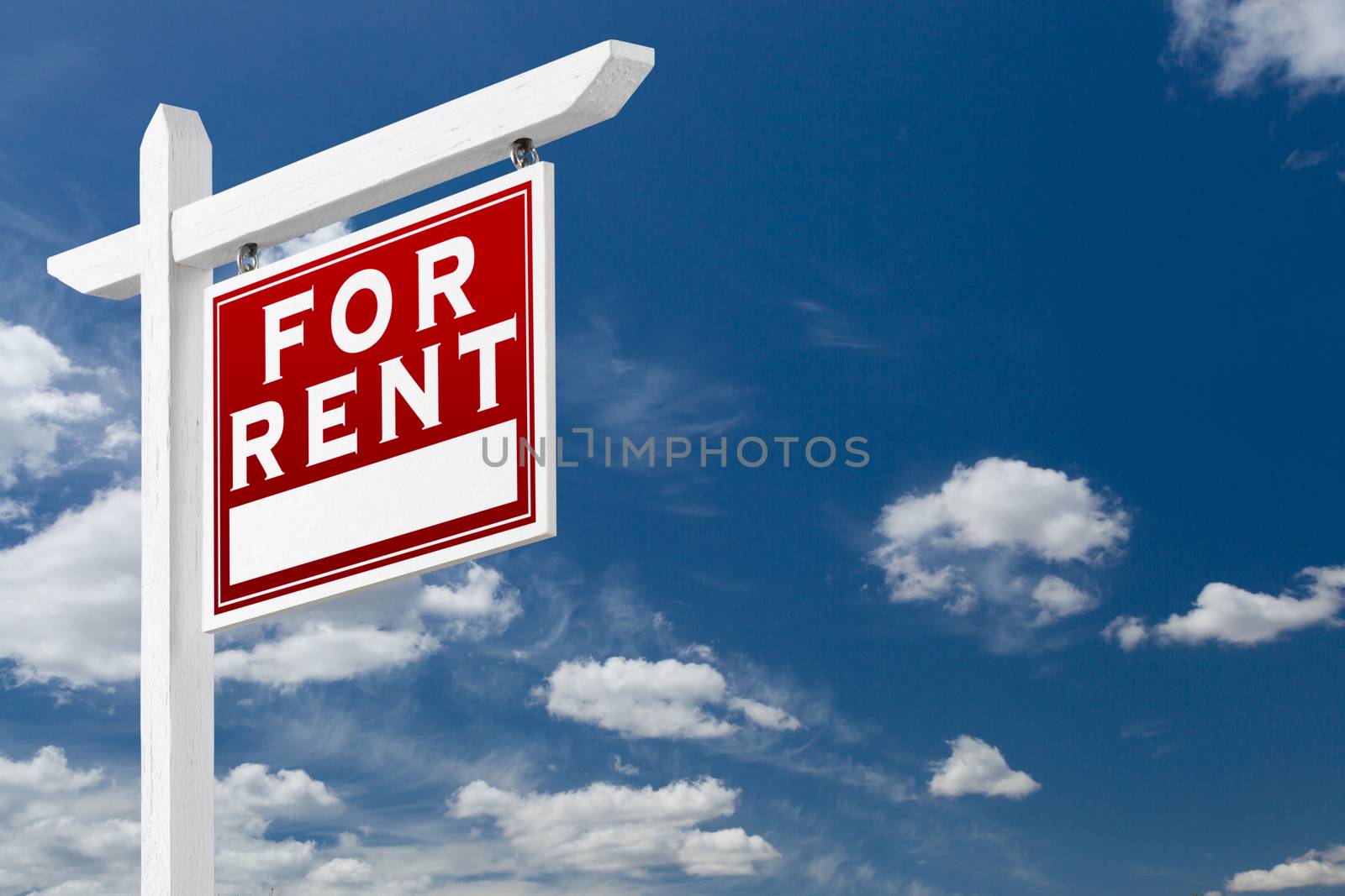 Right Facing For Rent Real Estate Sign Over Blue Sky and Clouds With Room For Your Text.