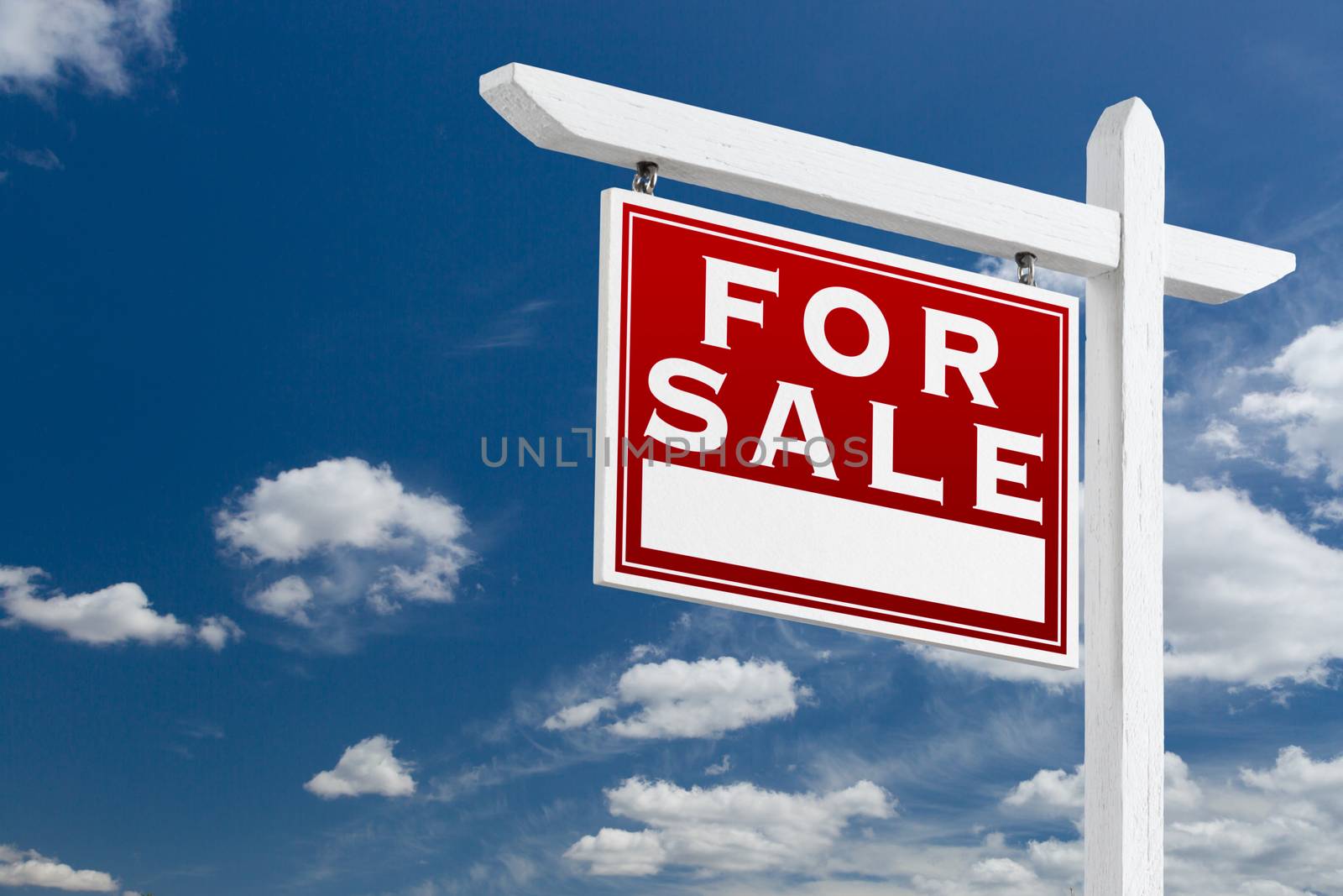 Left Facing For Sale Real Estate Sign Over Blue Sky and Clouds With Room For Your Text.