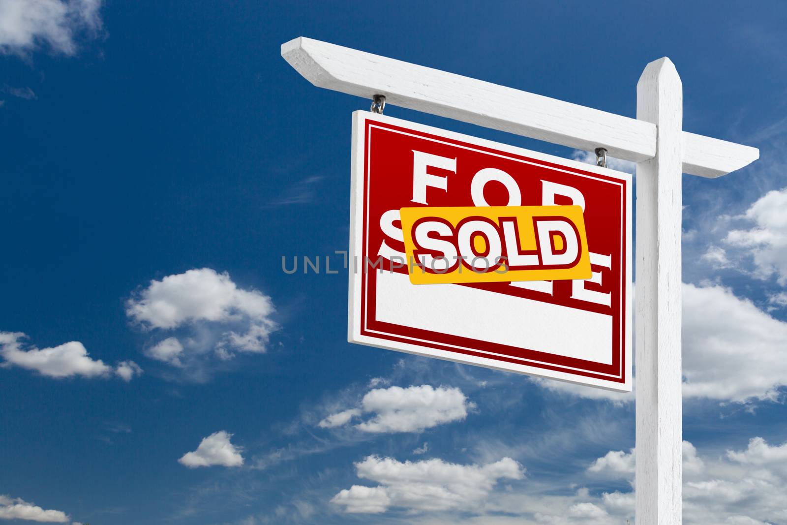 Left Facing Sold For Sale Real Estate Sign Over Blue Sky and Clouds With Room For Your Text.