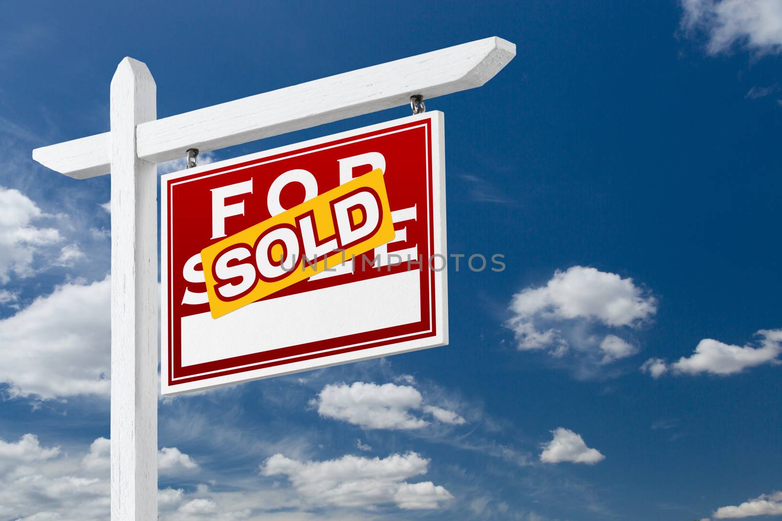 Right Facing Sold For Sale Real Estate Sign Over Blue Sky and Clouds With Room For Your Text.