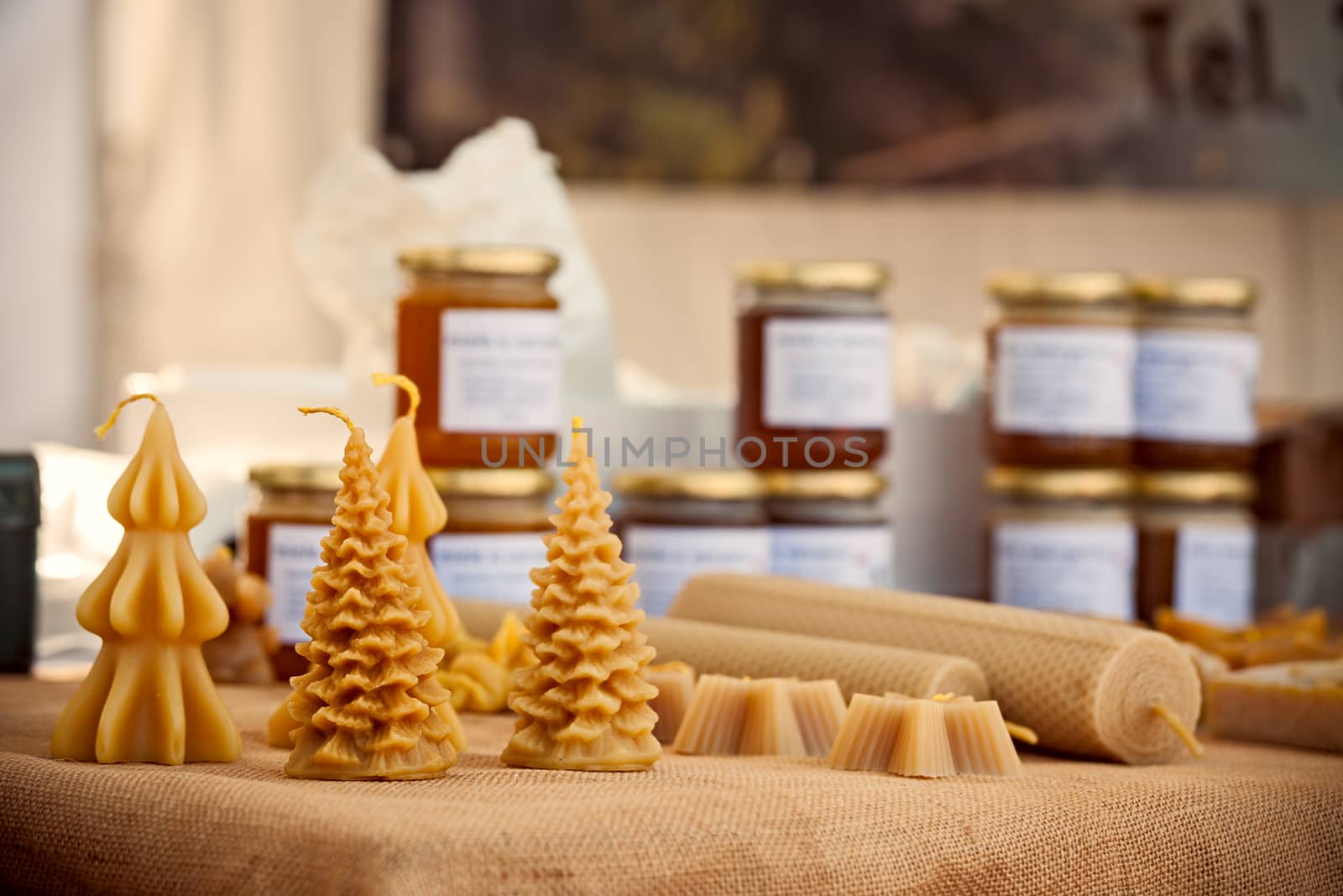 Various handicraft honeycandle over a table with honey jar on background