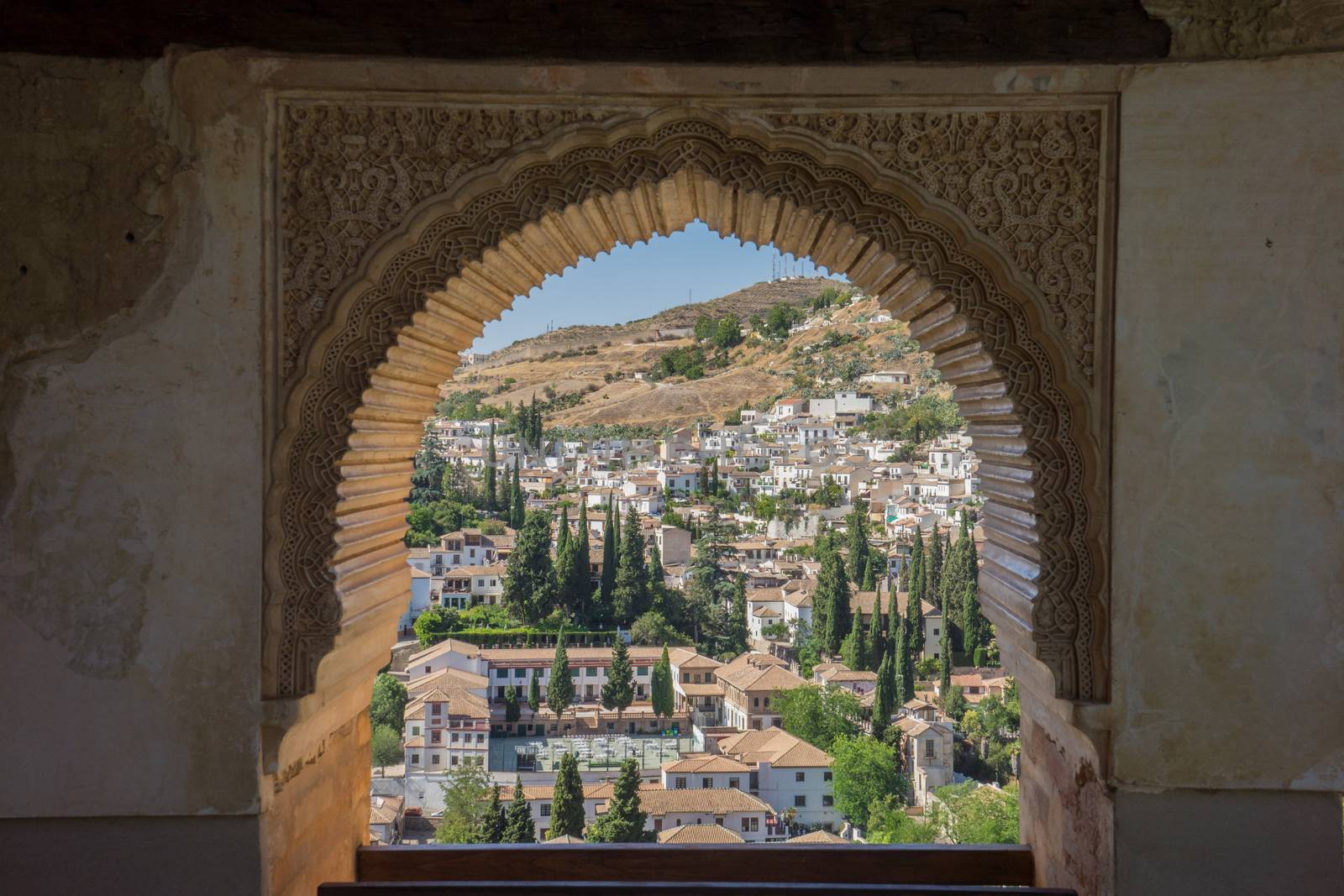 View of the Albayzin district of Granada, Spain, from a window in the Alhambra palace near sunset at Granada, Spain, Europe on a bright sunny day