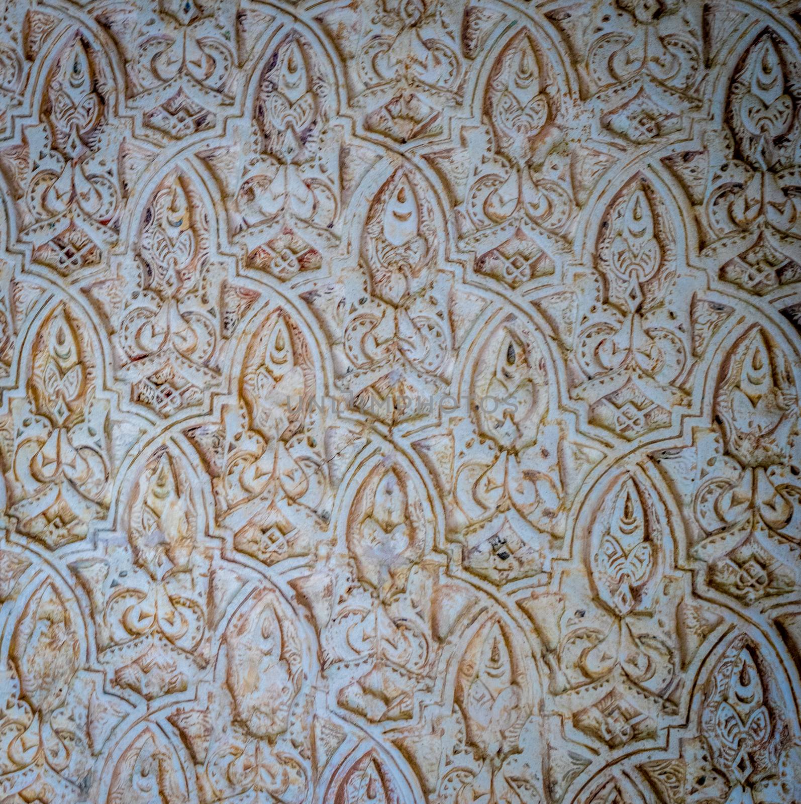 Arabic moorish design pattern with white plaster on the walls of the Alhambra at Granada, Spain, Europe on a bright sunny summer day