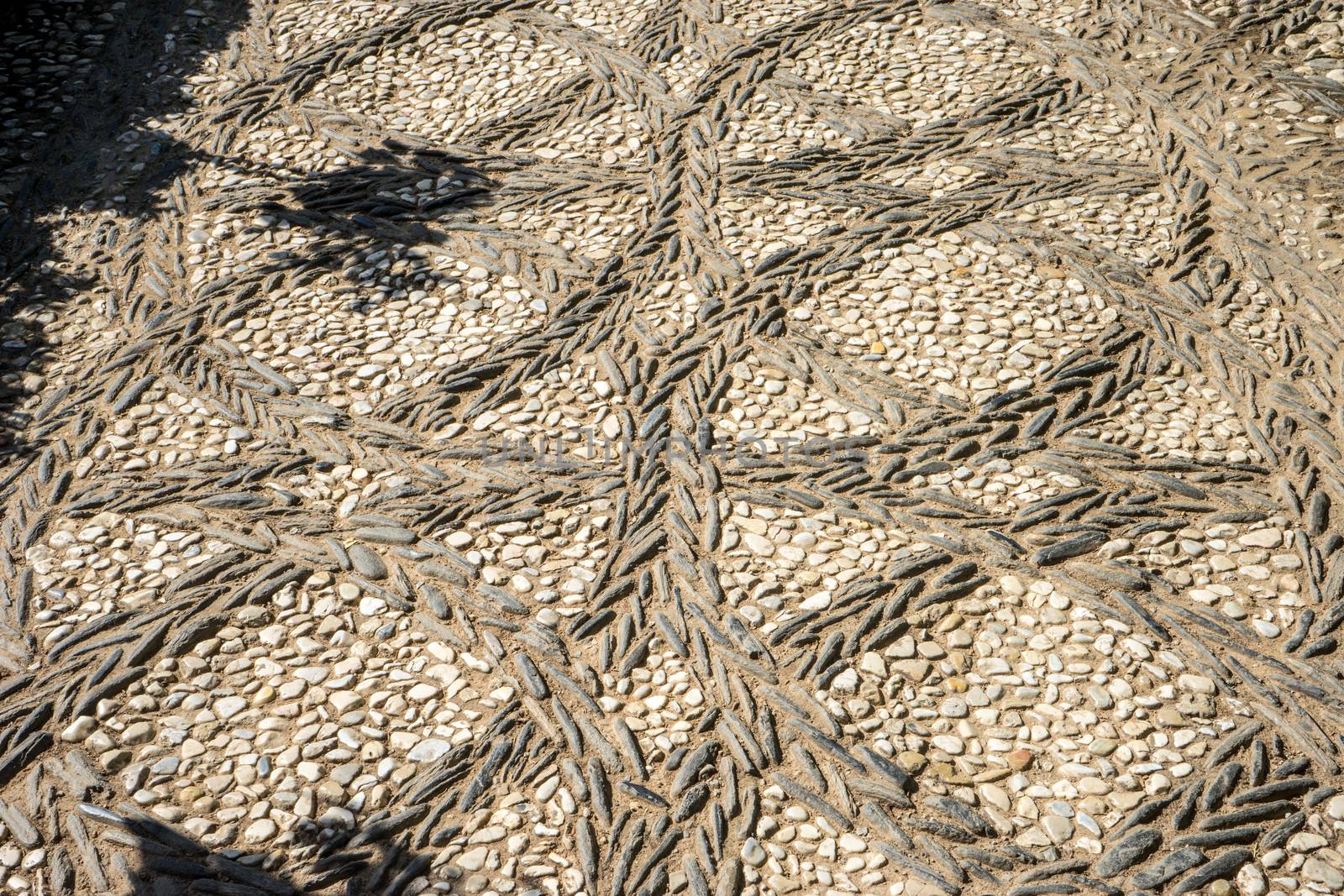 Circular patterns on a stone walking path at the Alhambra palace in Granada, Spain, Europe on a bright summer day