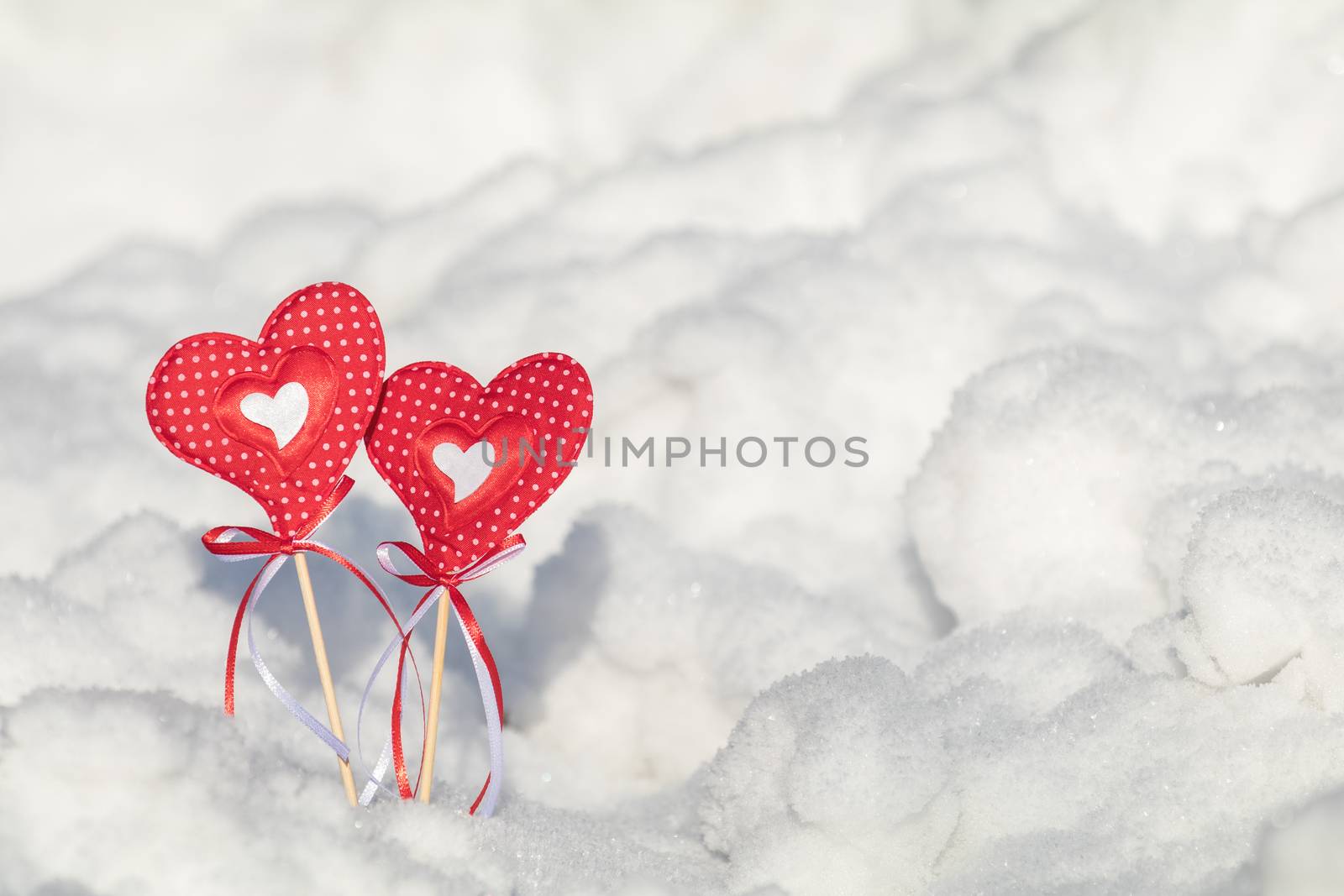 Beautiful valentine holiday background with two checkered hearts on cane, white snow surface.