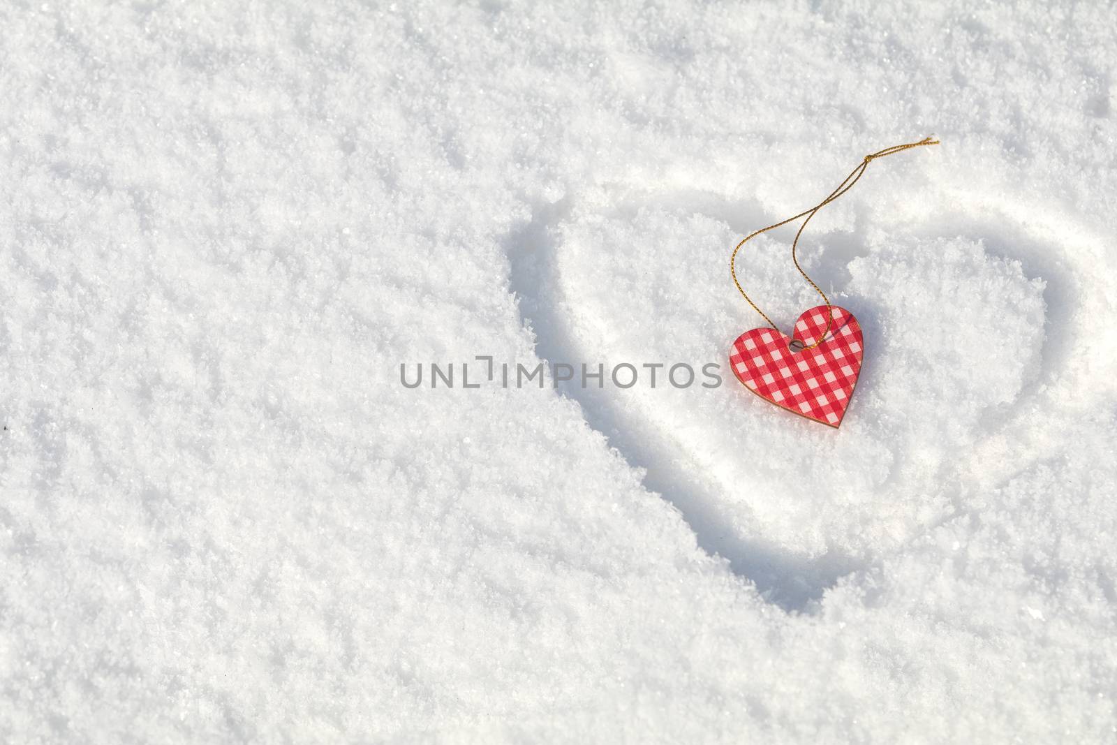 Beautiful valentine holiday background with checkered motley heart on white snow surface.