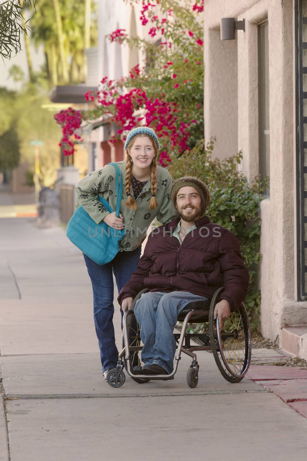 Woman with friend in wheelchair on city sidewalk