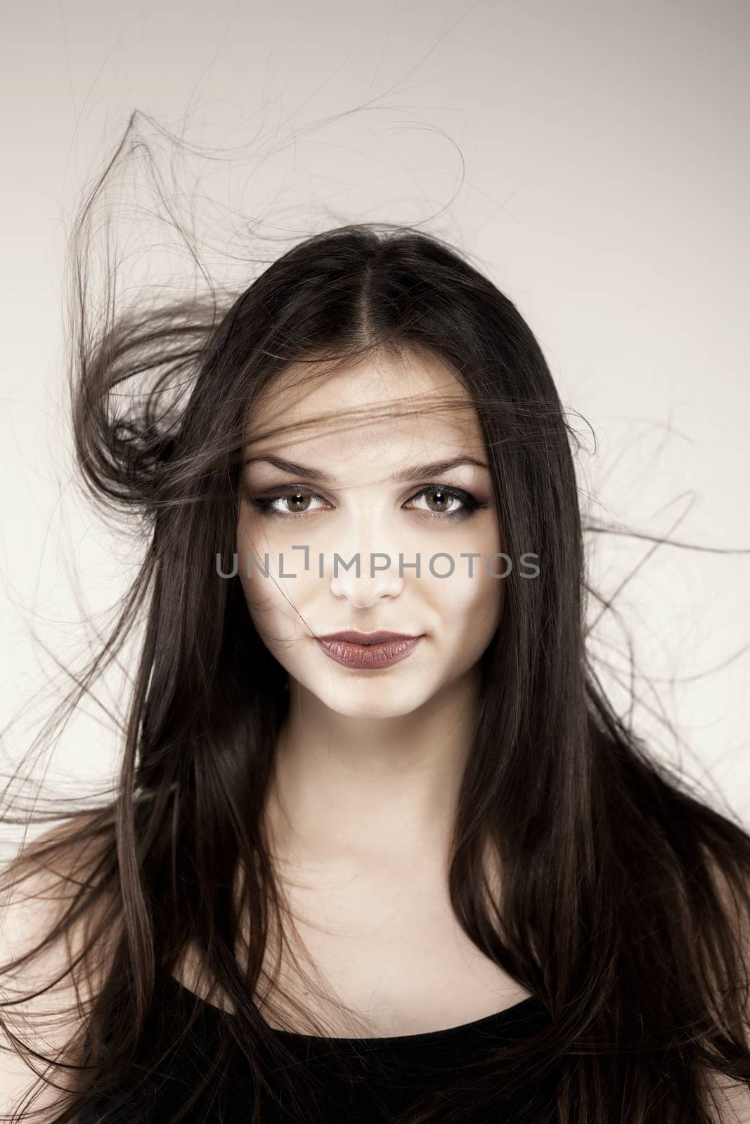 portrait of young sexy girl with long hair in the air on dark background in studio, goth style