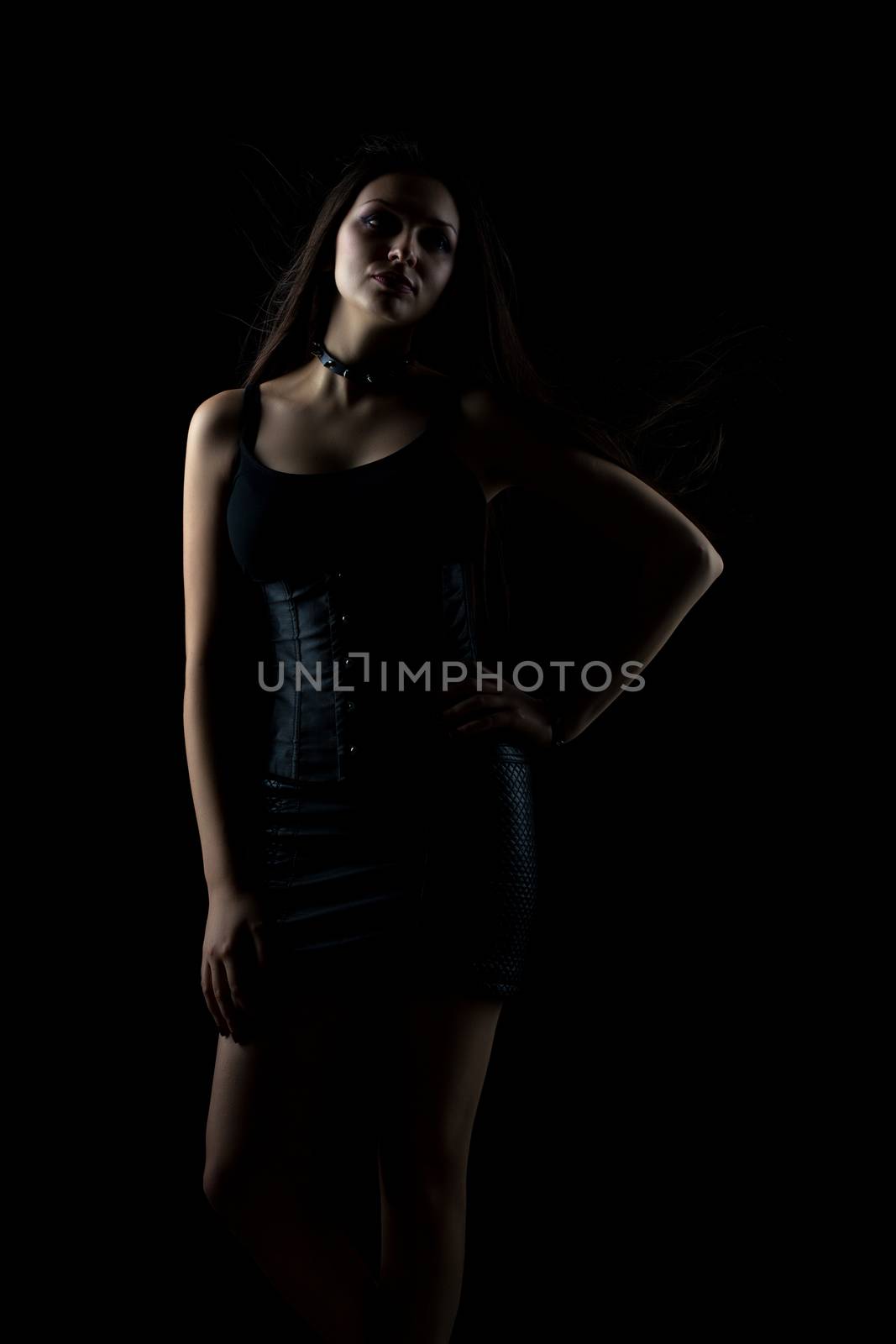 portrait of young sexy girl with long hair on dark background in studio, goth style