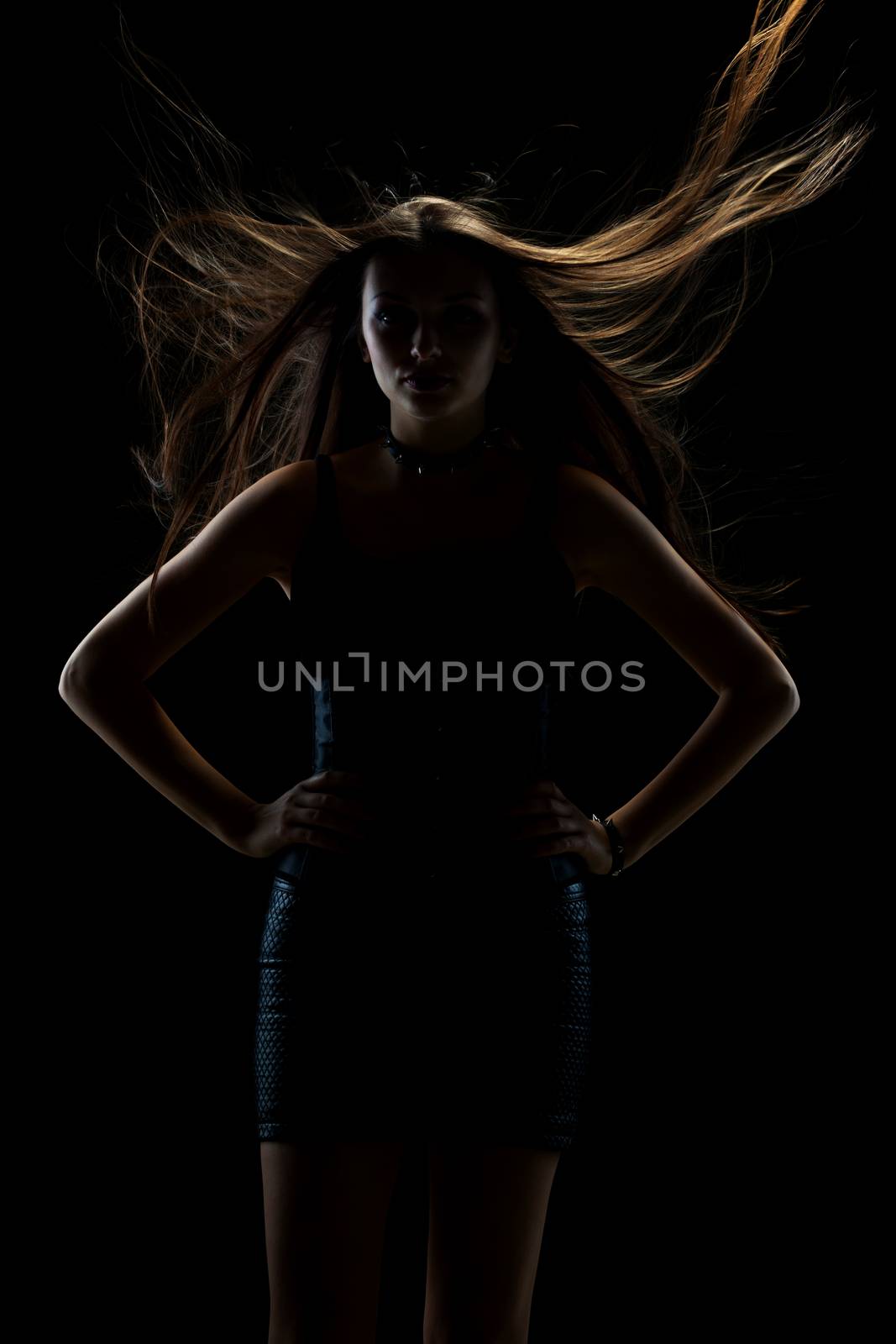 portrait of young sexy girl with long hair in the air on dark background in studio, goth style