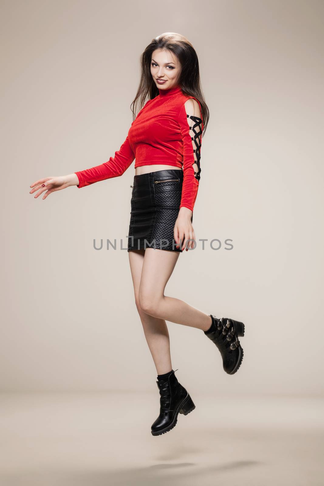 jumping girl in red shirt, short black dress and boots