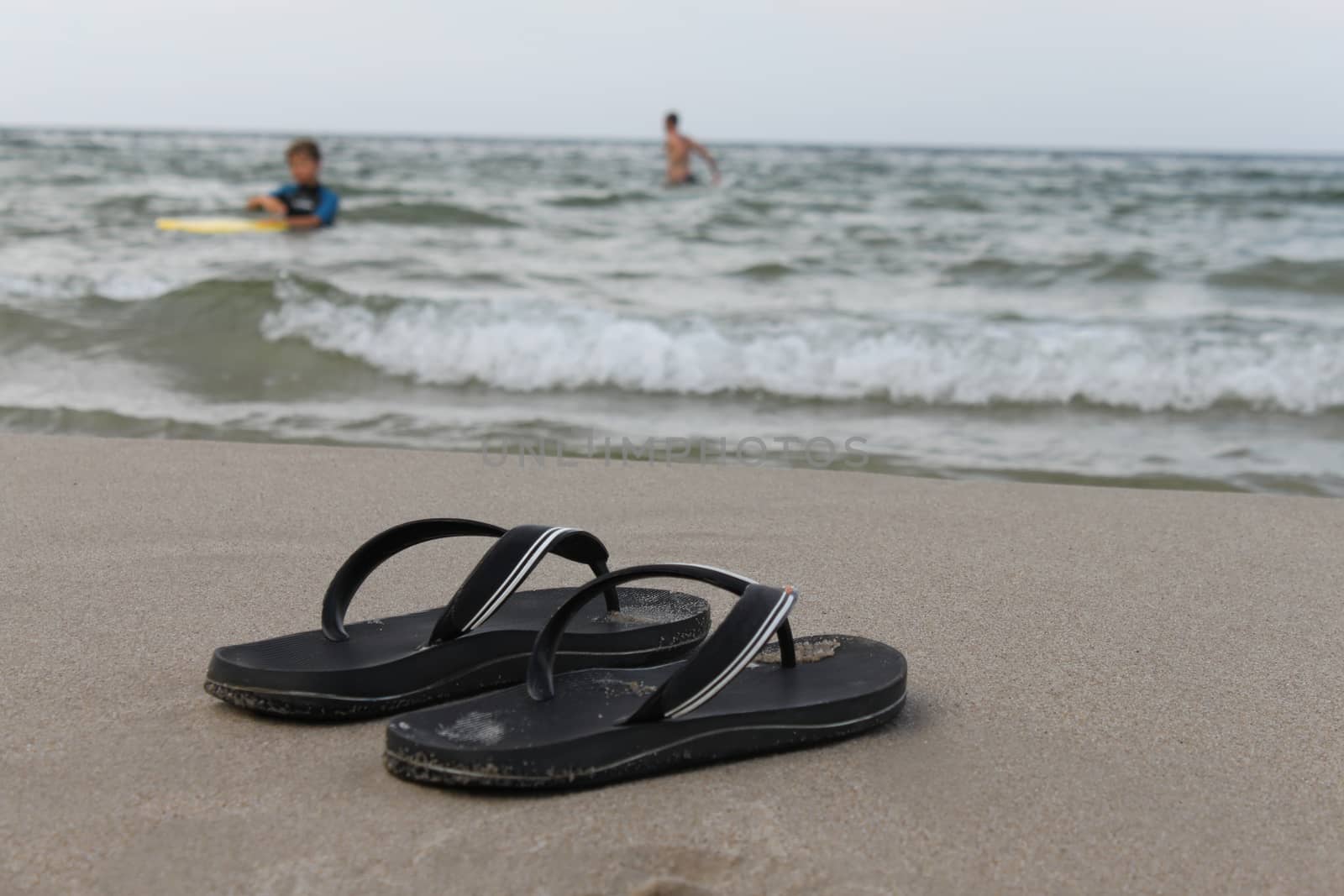 Slippers on the background of the sea and the beach by Kasia_Lawrynowicz