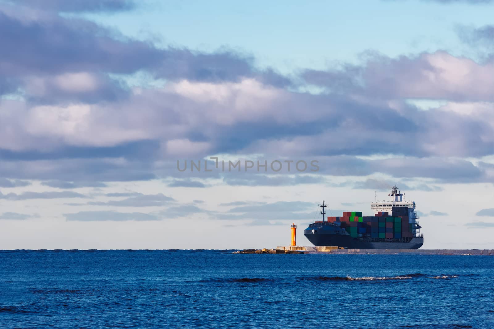 Modern grey container ship moving in still water