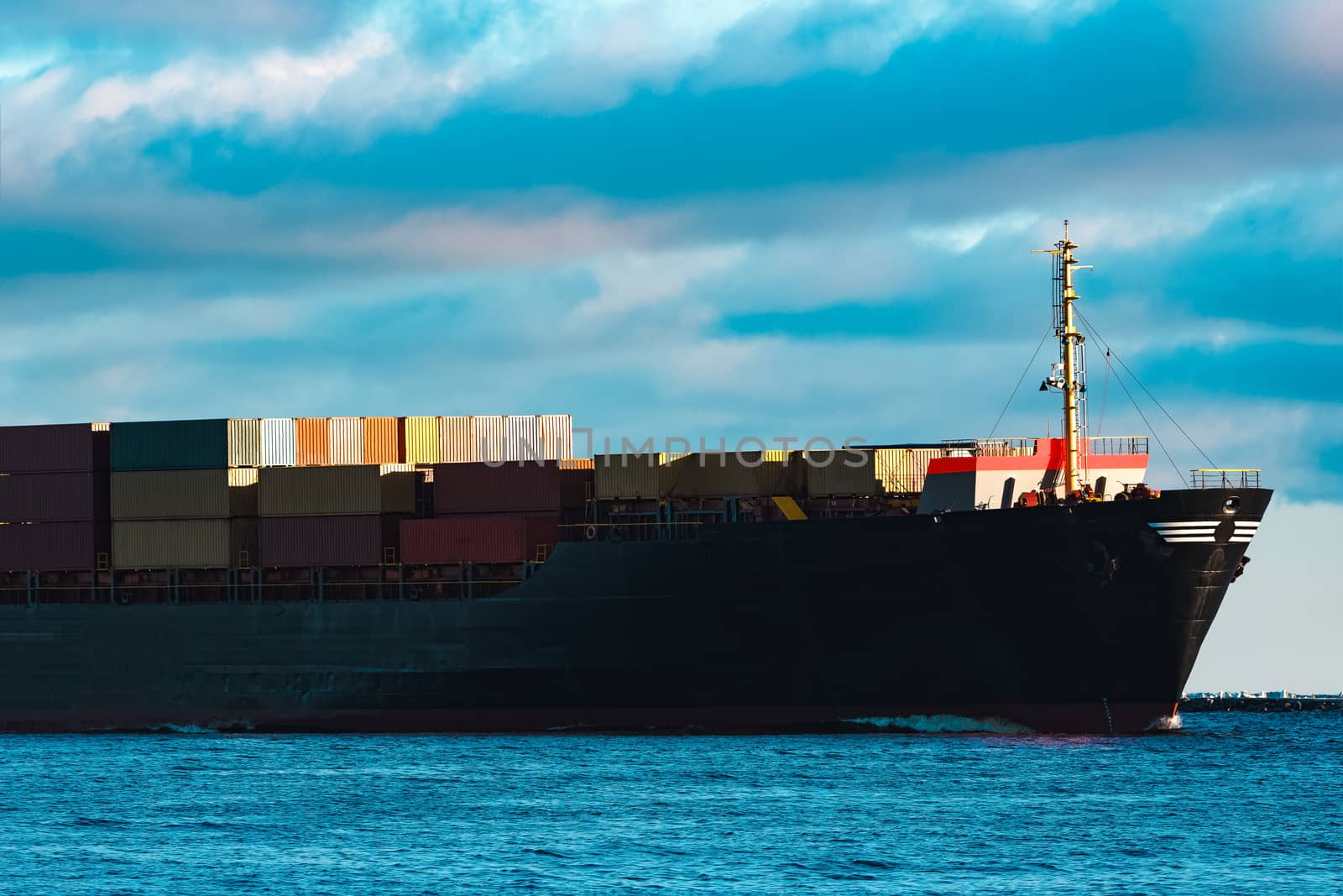 Modern black container ship moving from Baltic sea