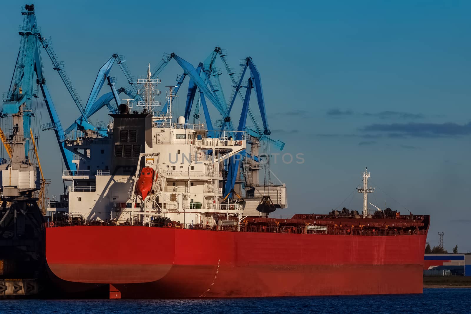 Red cargo ship loading in the port of Riga, Europe