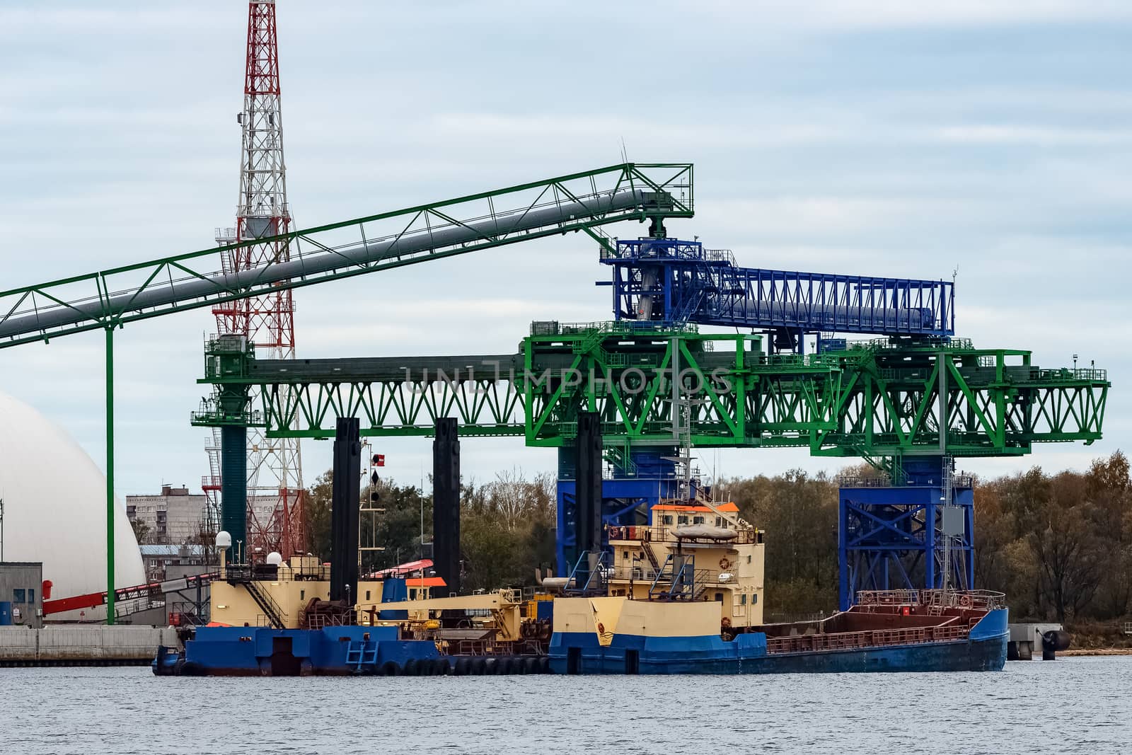 Blue cargo ship loading in the port of Riga, Europe