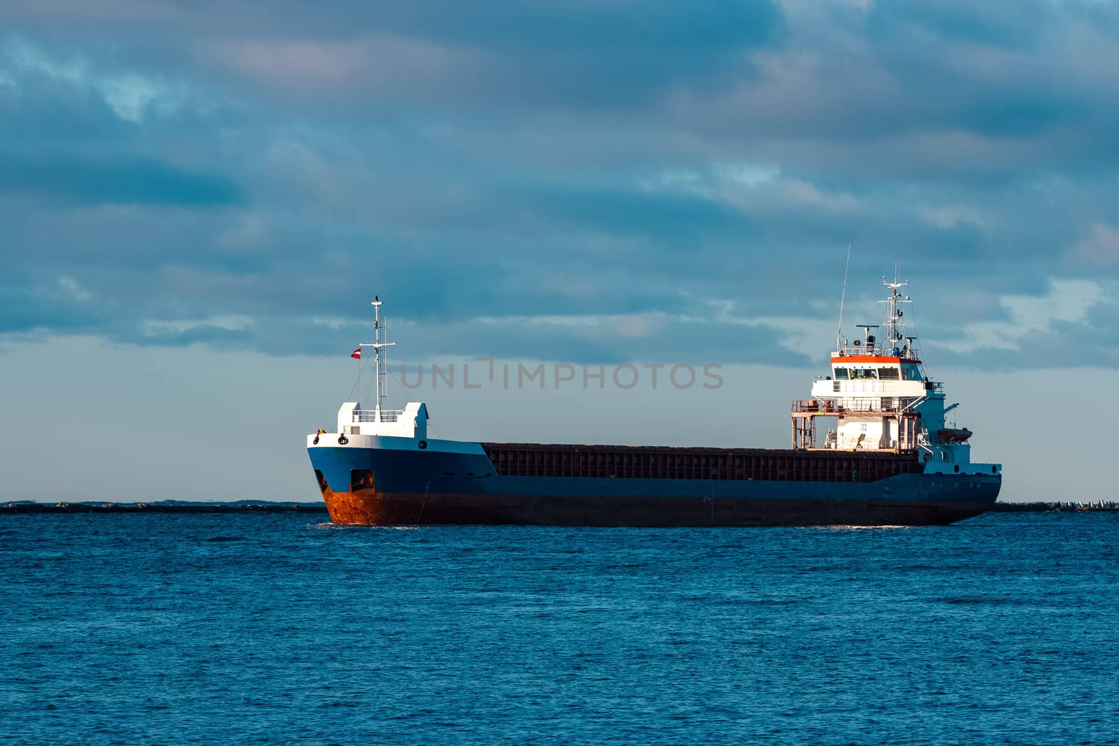 Blue bulk carrier sailing in still water