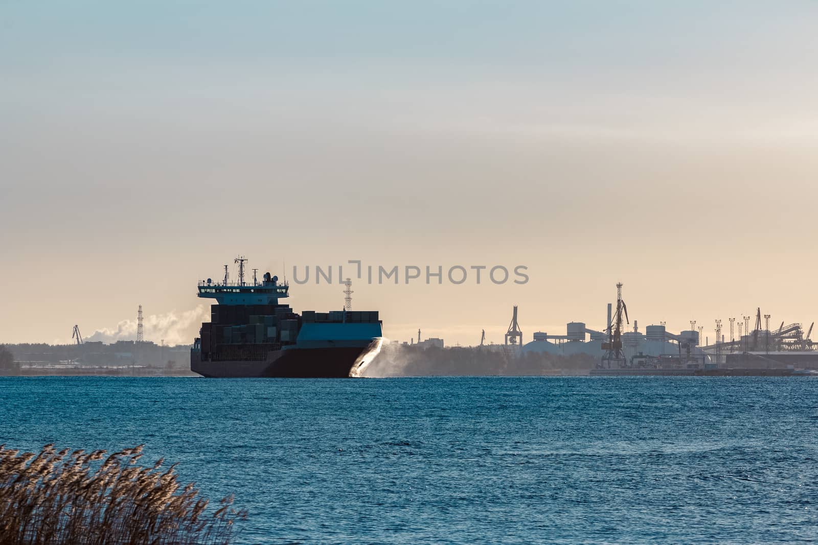 Full red container ship moving in still water