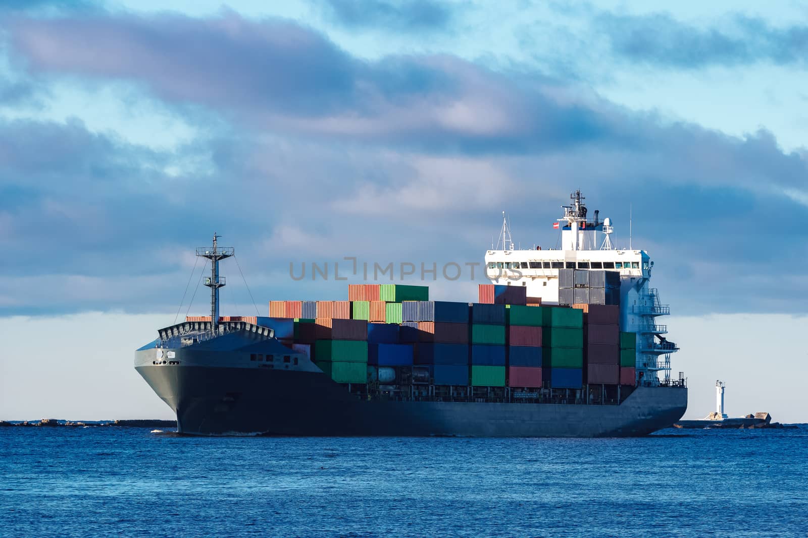 Modern grey container ship moving in still water