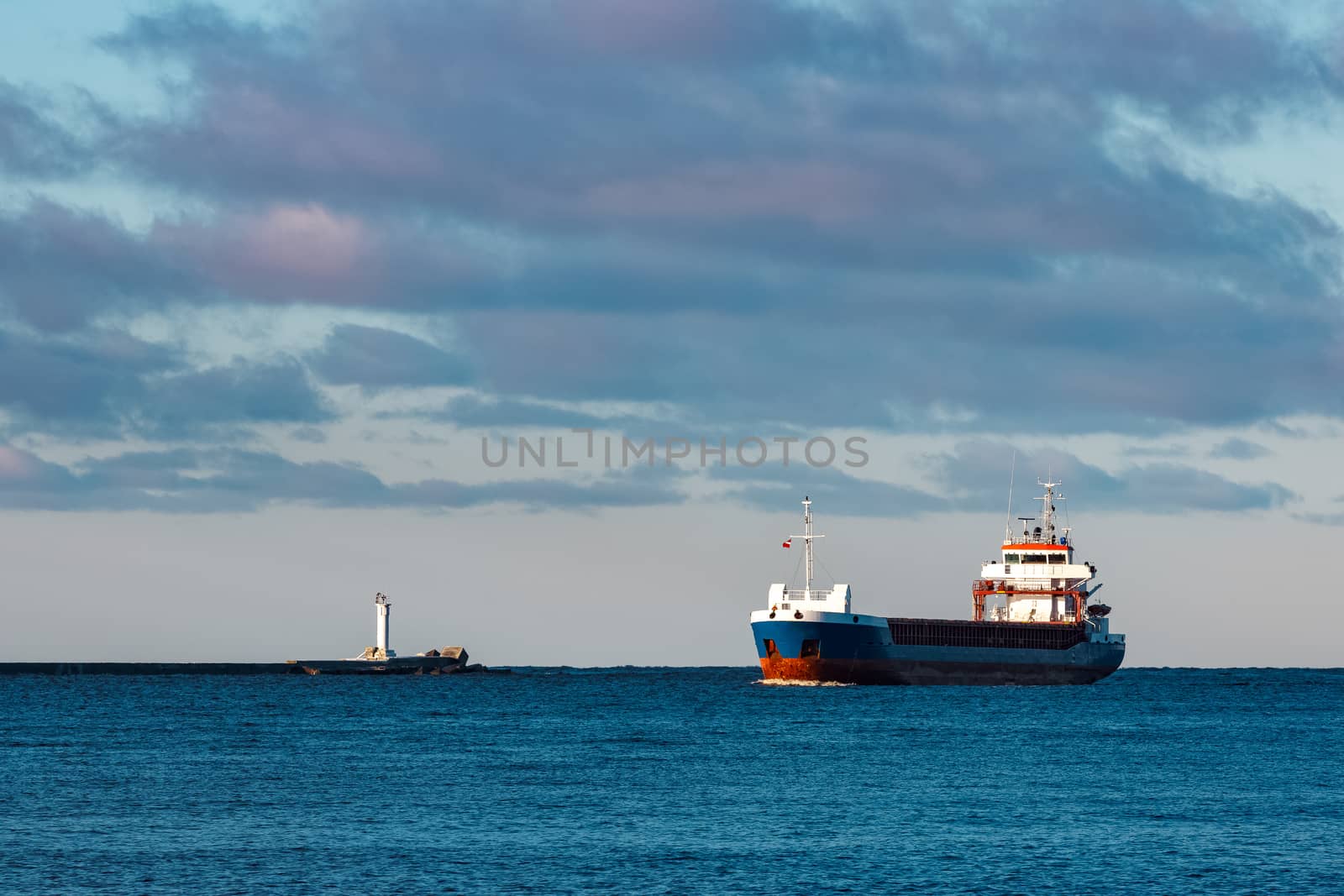 Blue bulk carrier sailing in still water