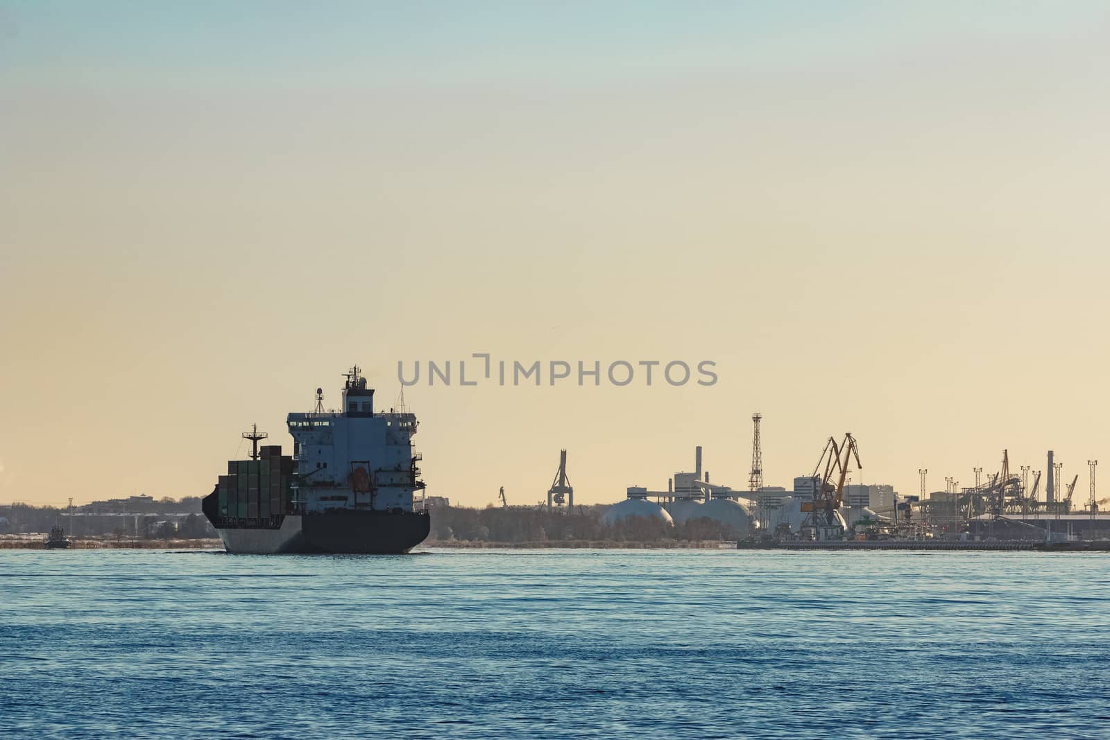 Modern grey container ship moving in still water