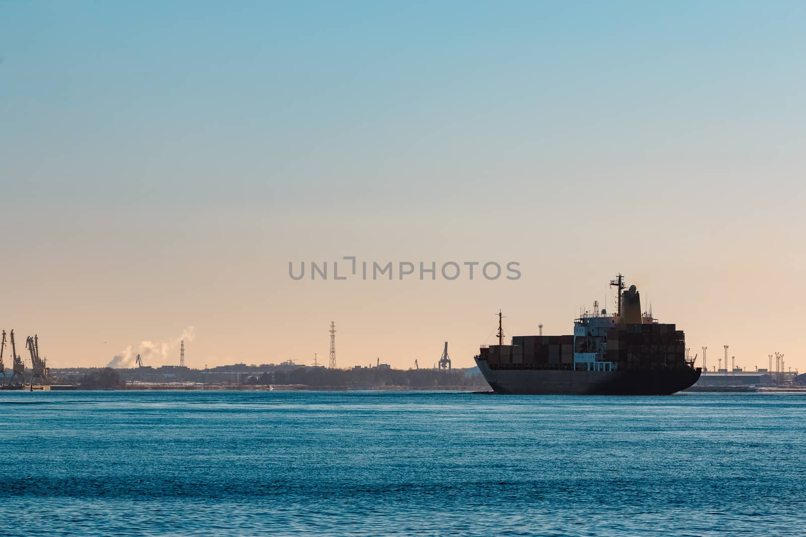 Modern black container ship moving from Baltic sea