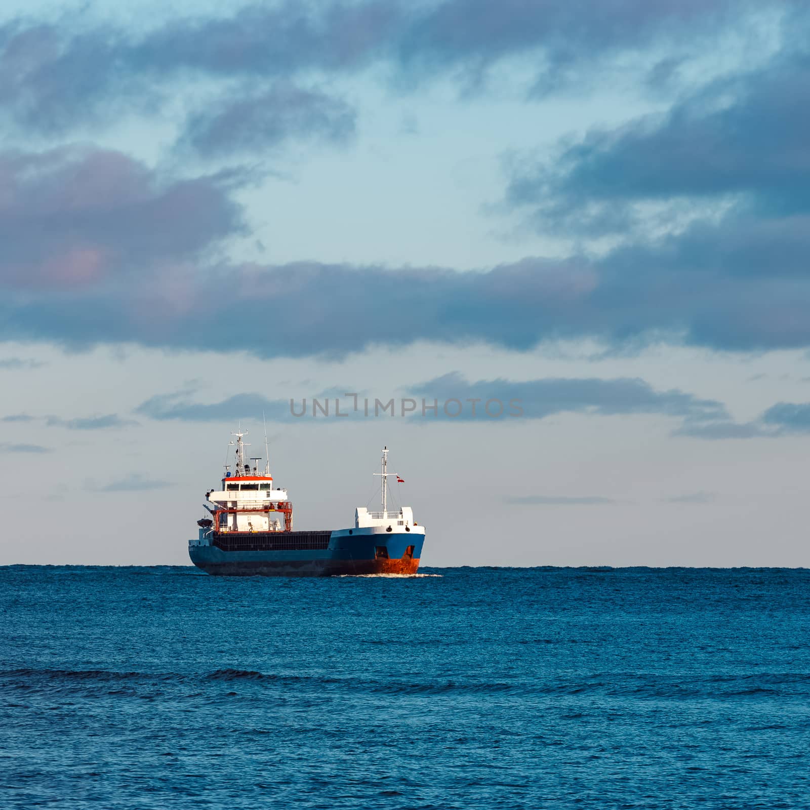 Blue bulk carrier sailing in still water