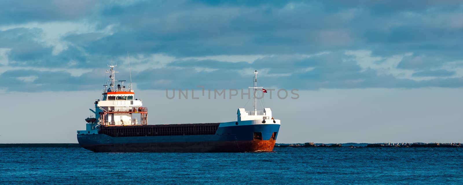 Blue bulk carrier sailing in still water