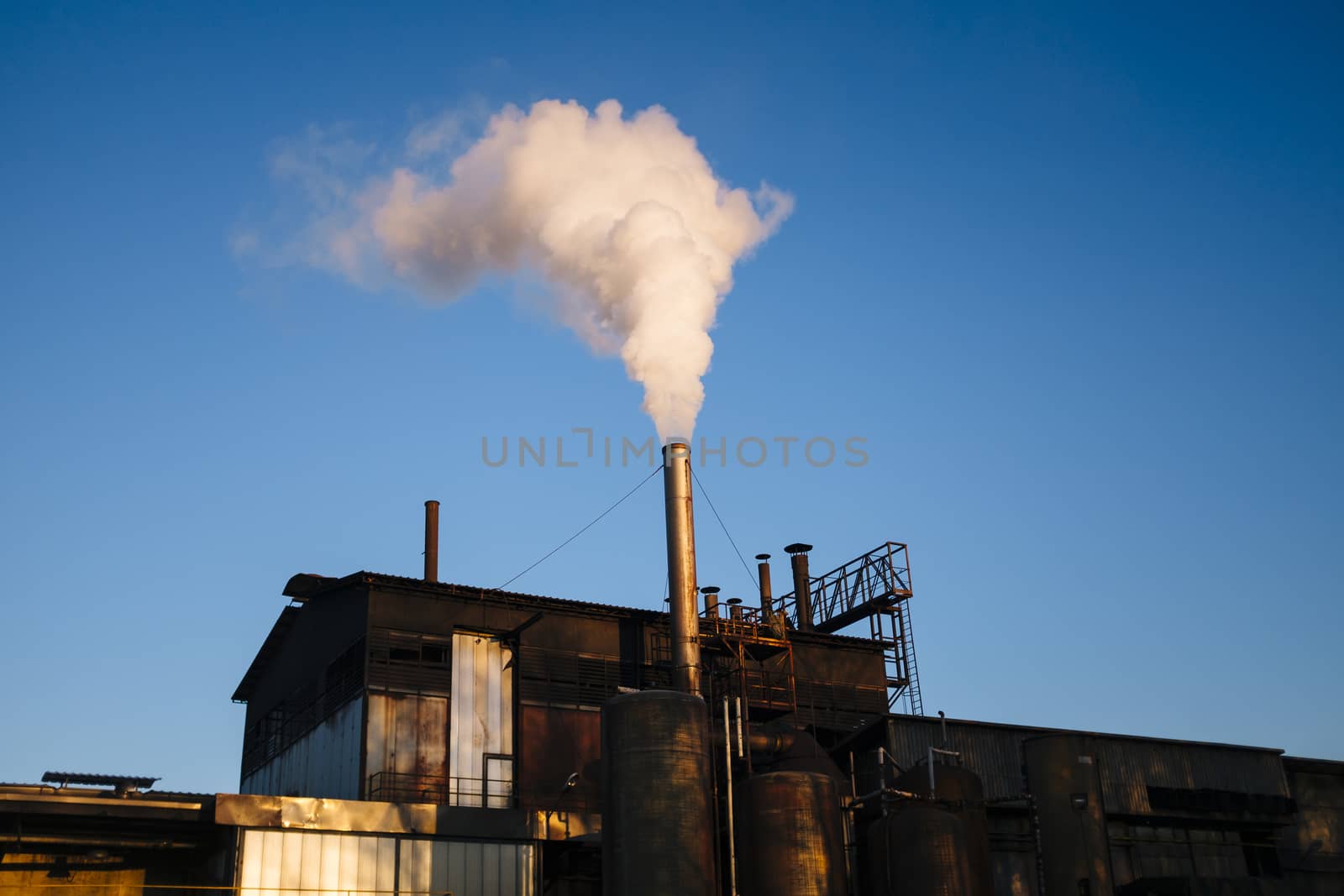 factory emits steam-smoke water in the blue sky