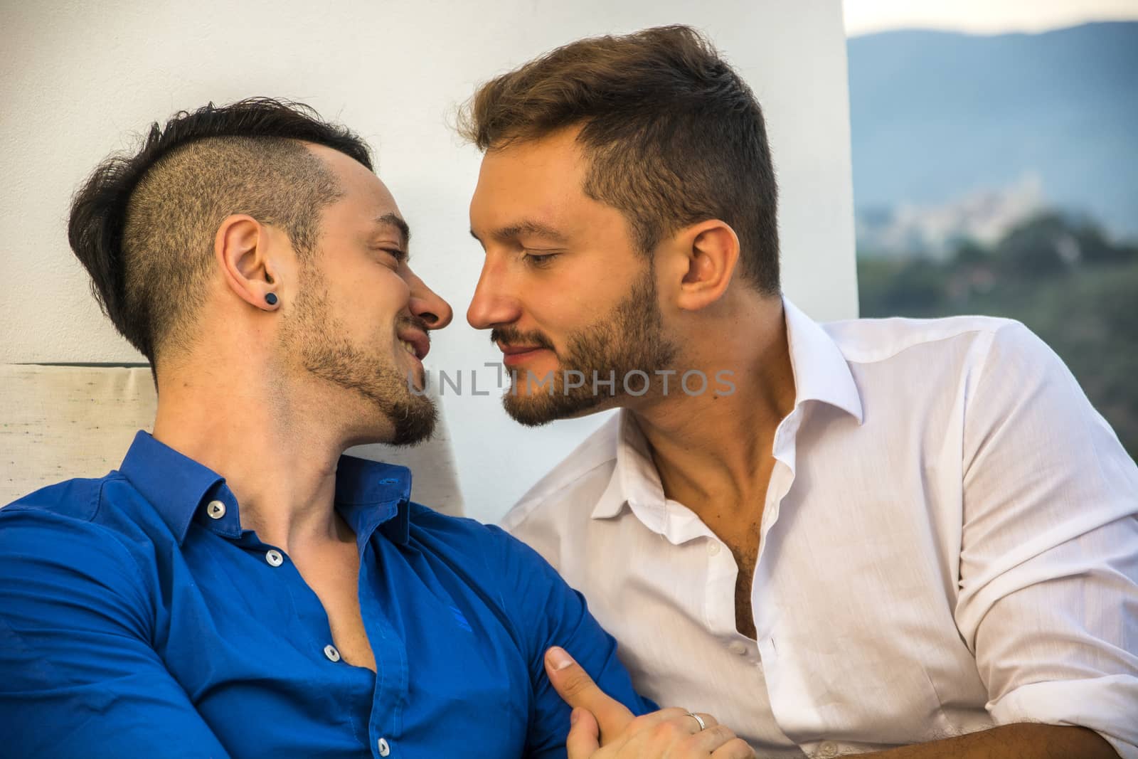 Homosexual couple on chairs at balcony by artofphoto