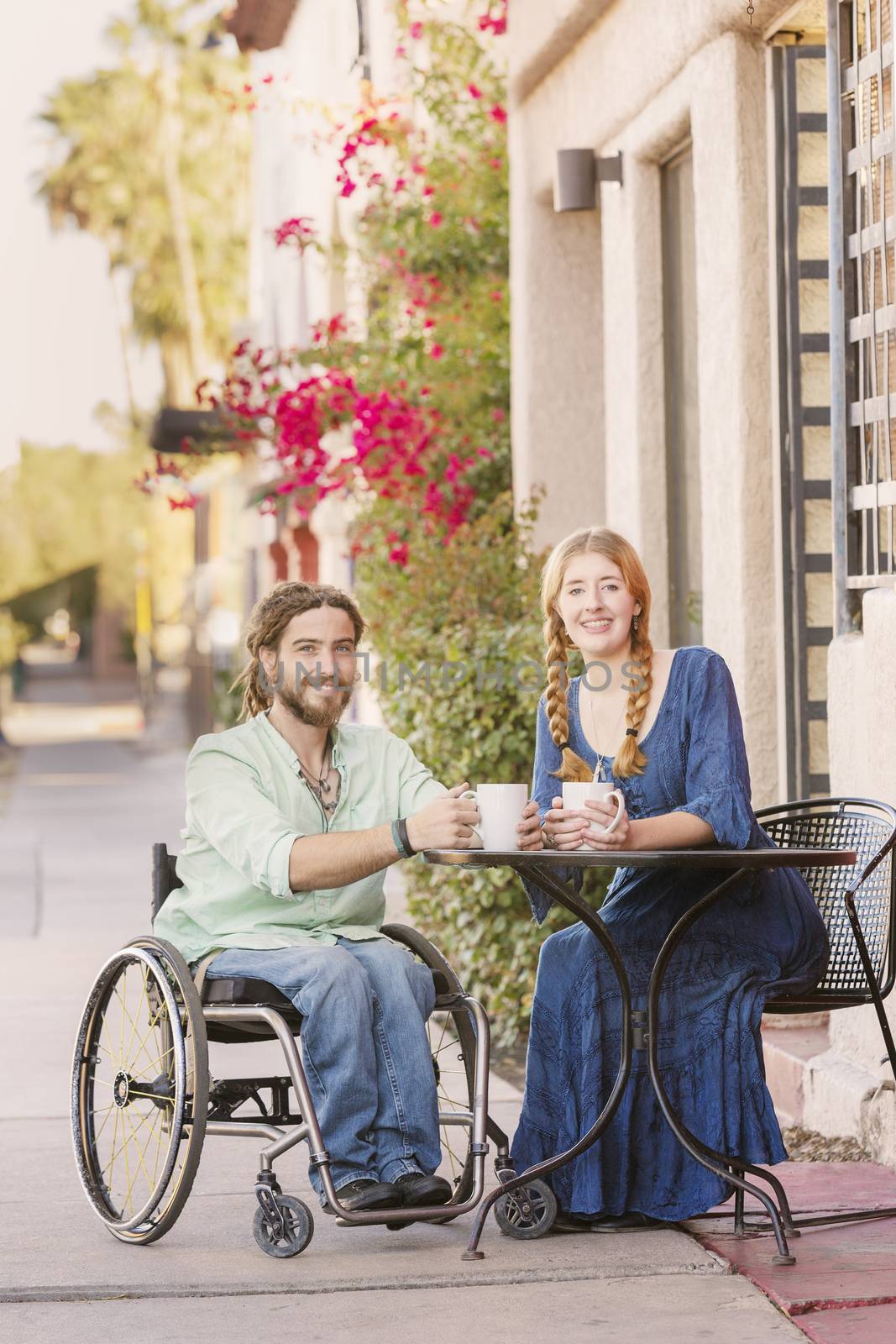 Woman and male friend in wheelchair having coffee