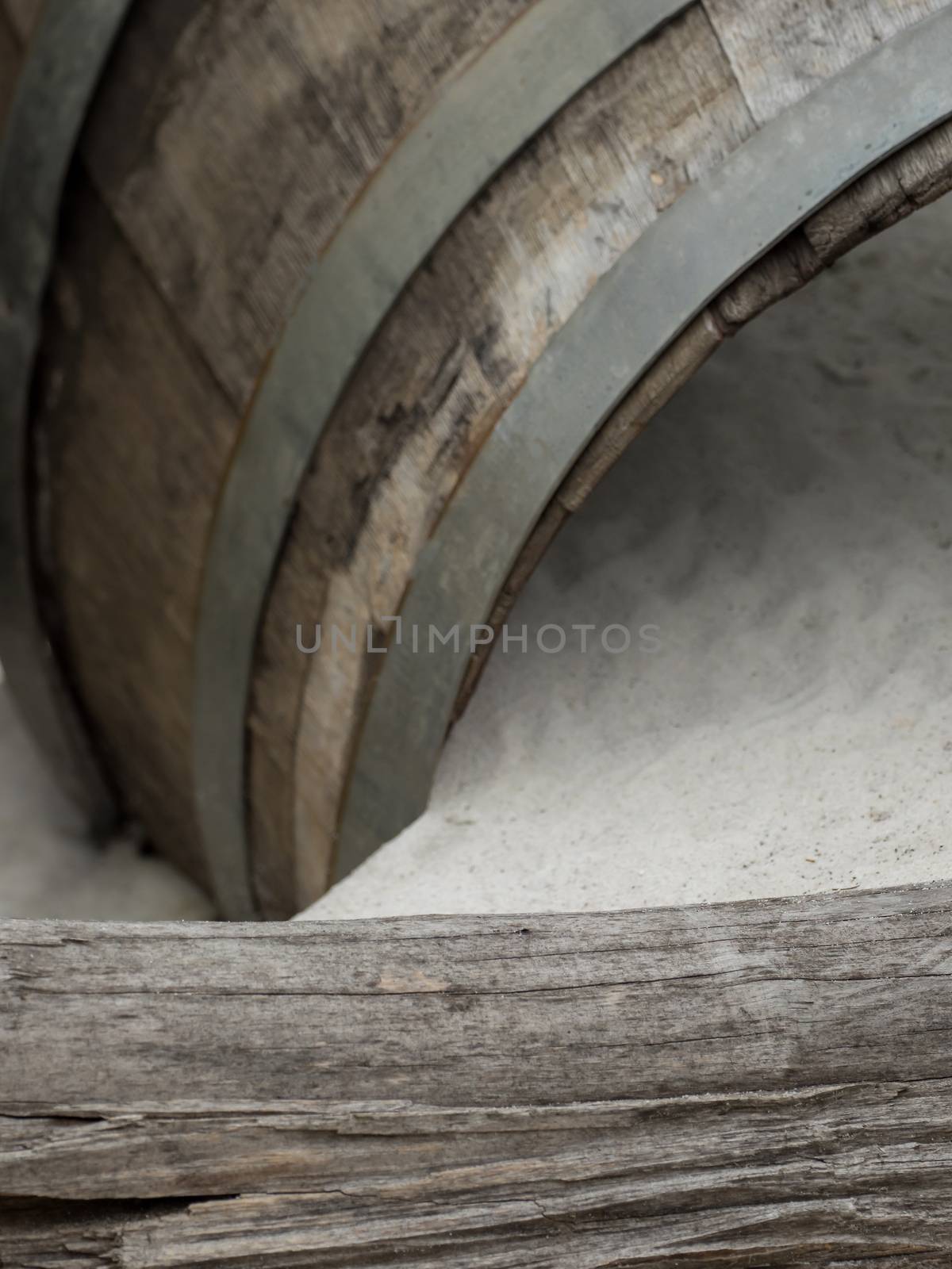 An old wooden barrel lies in the sand