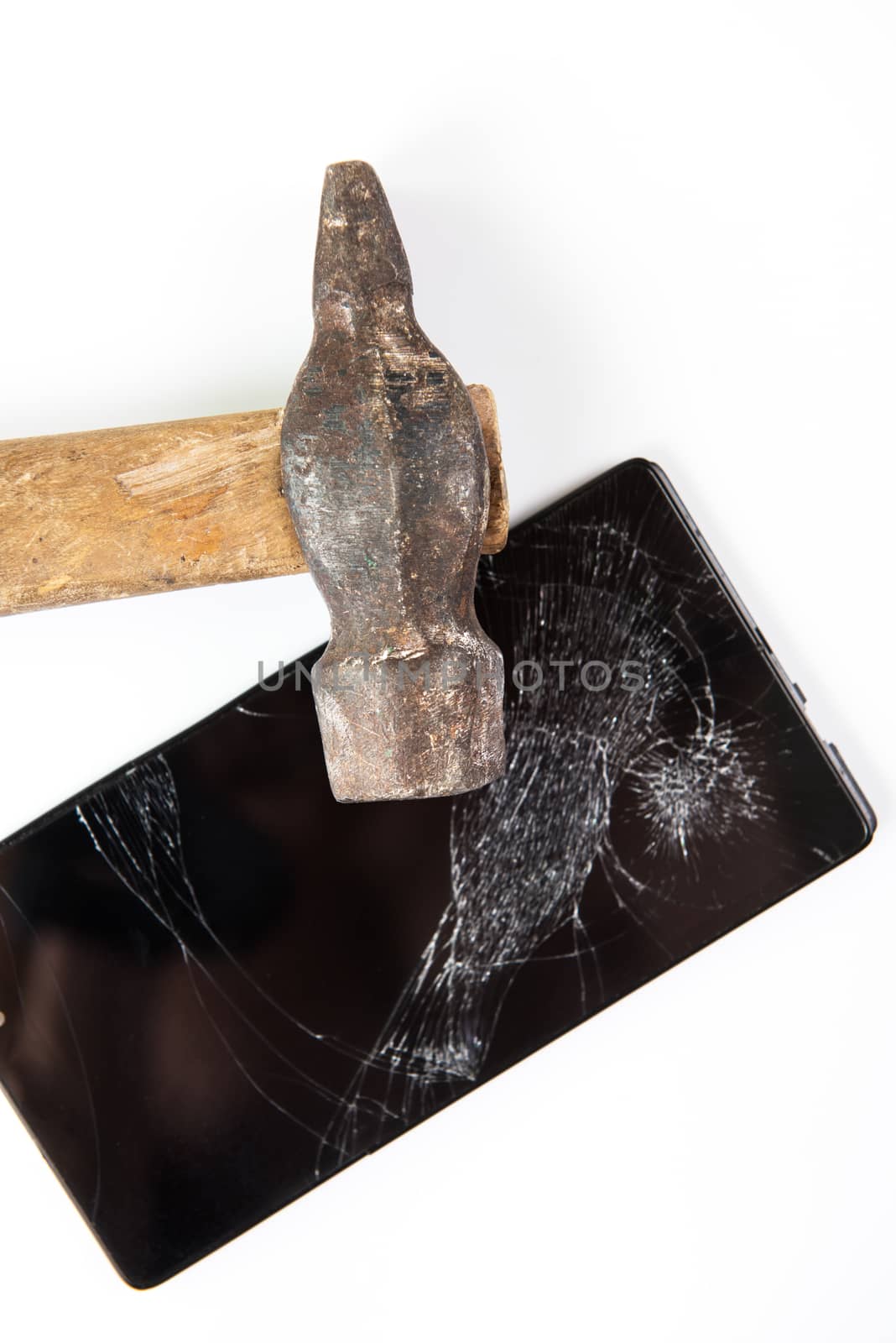 An old hammer and smartphone with broken screen on a white background