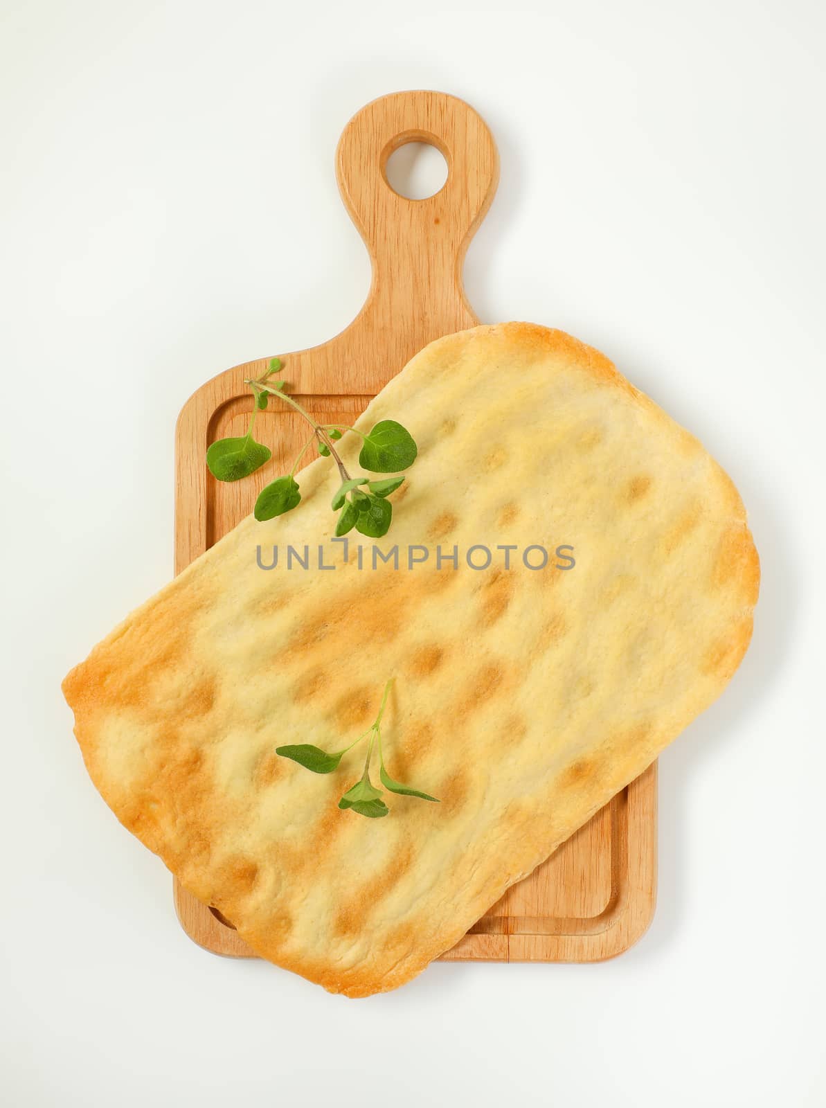 piece of traditional Tuscan flatbread (Ghiottina Toscana) on wooden cutting board