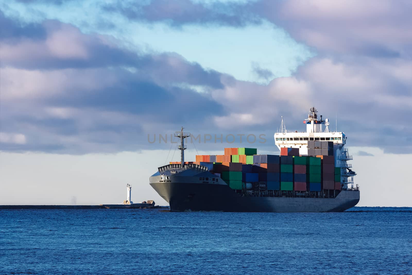 Modern grey container ship moving in still water