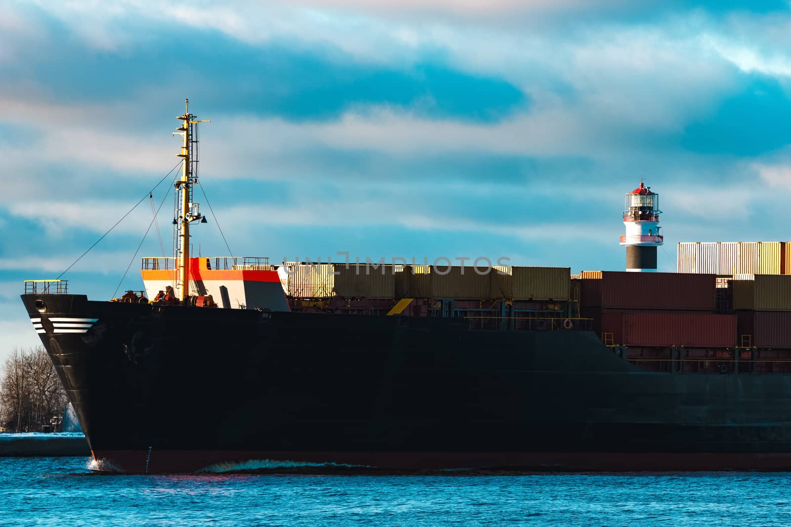 Modern black container ship moving from Baltic sea