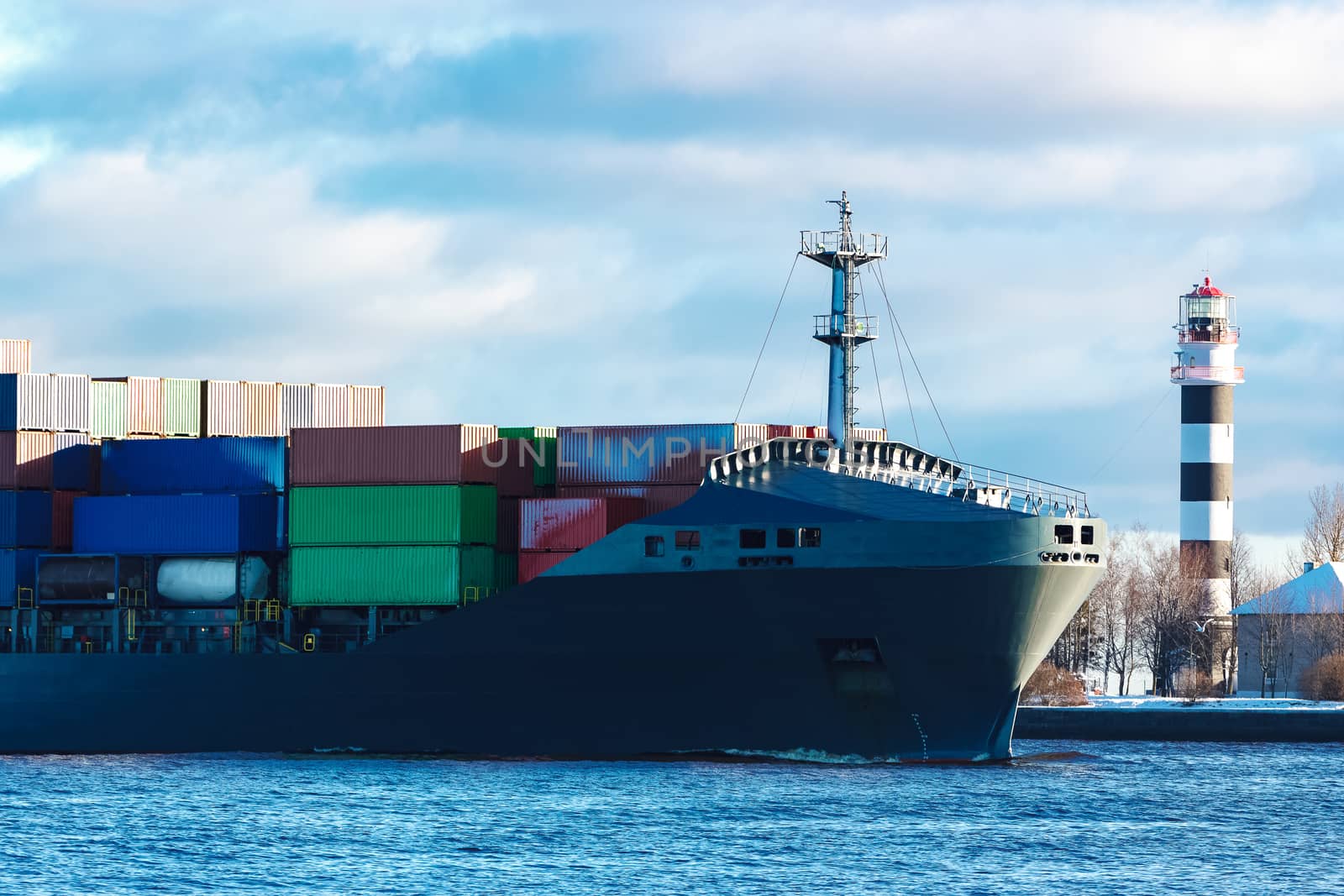 Modern grey container ship moving in still water
