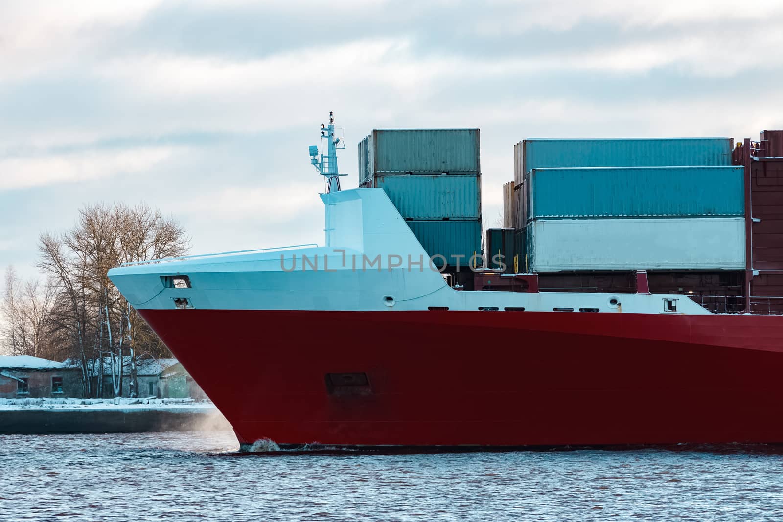 Full red container ship moving in still water