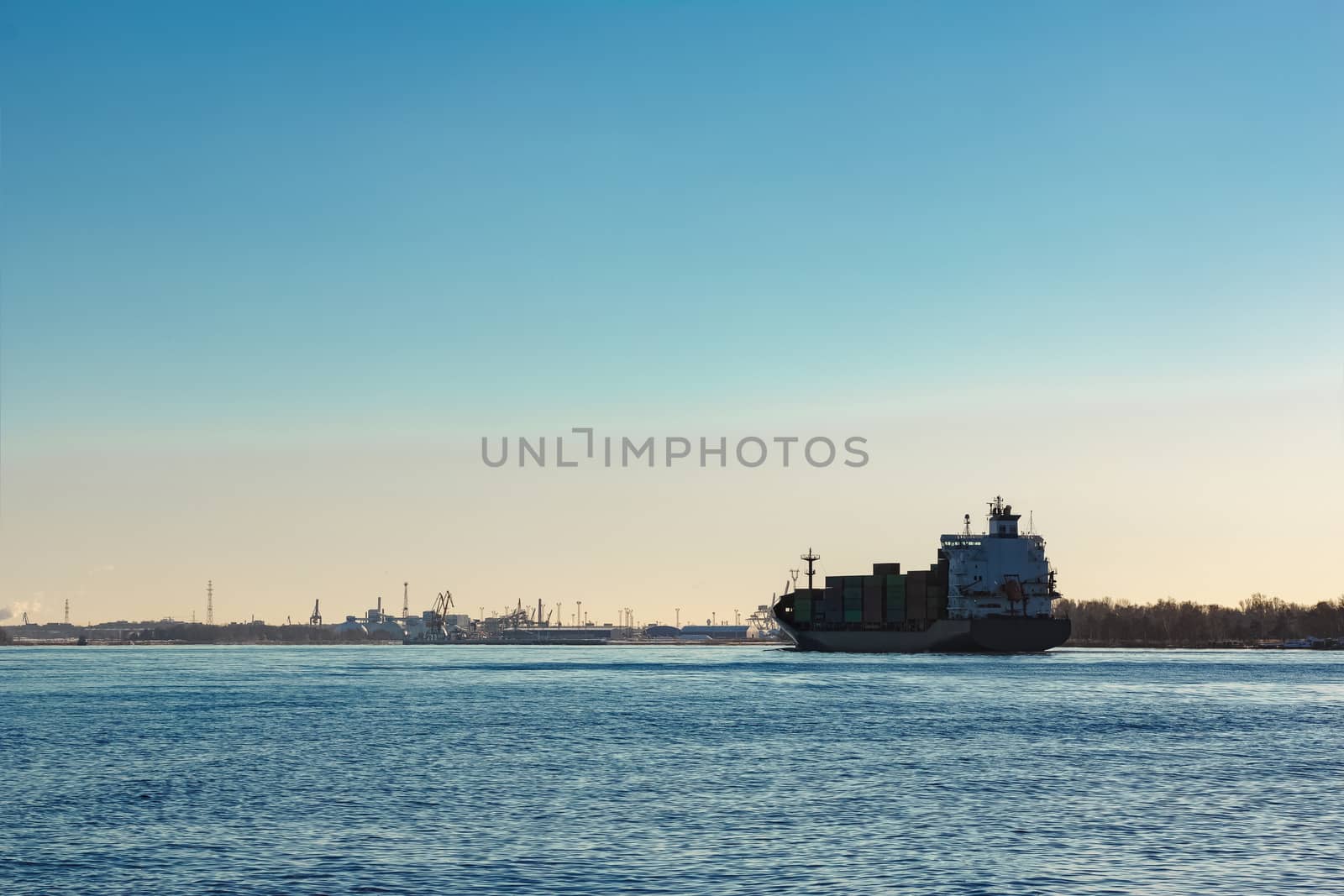 Modern grey container ship moving in still water