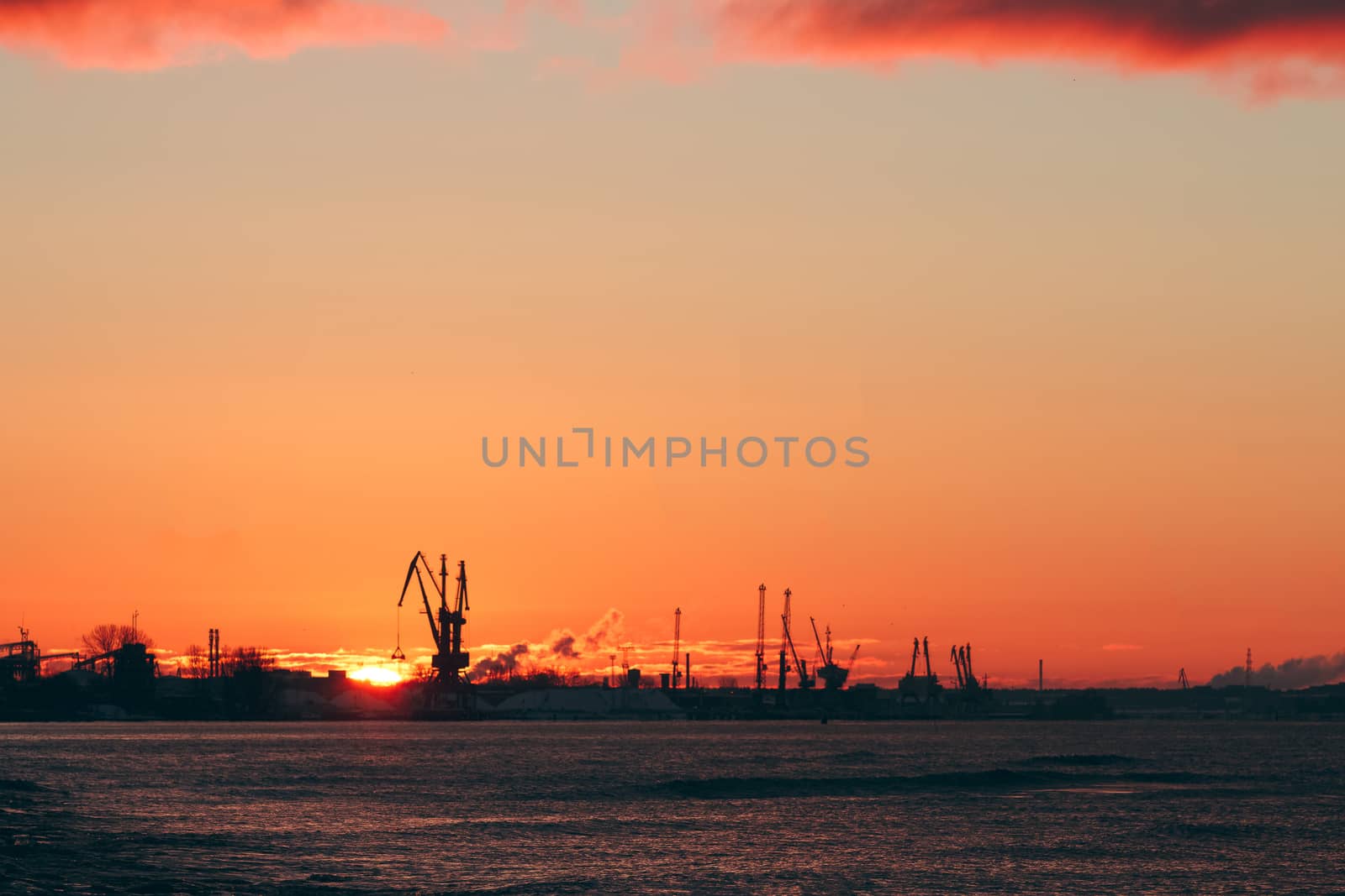 Hot winter sunrise over the cargo port in Riga