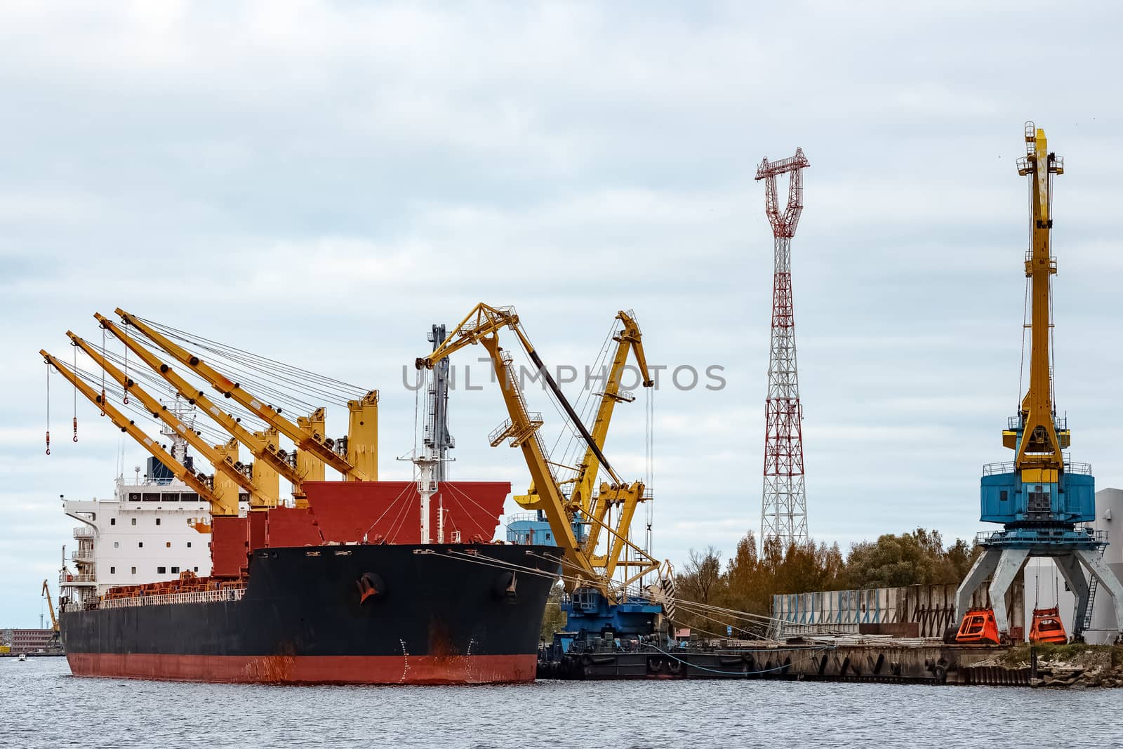 Black cargo ship loading in the port of Riga, Europe