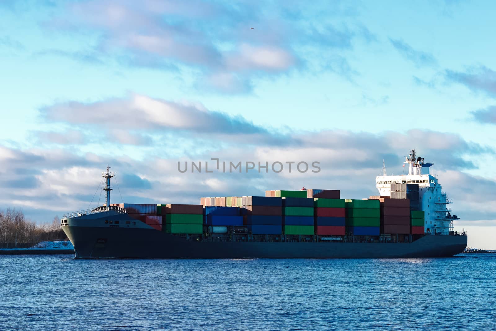 Modern grey container ship moving in still water