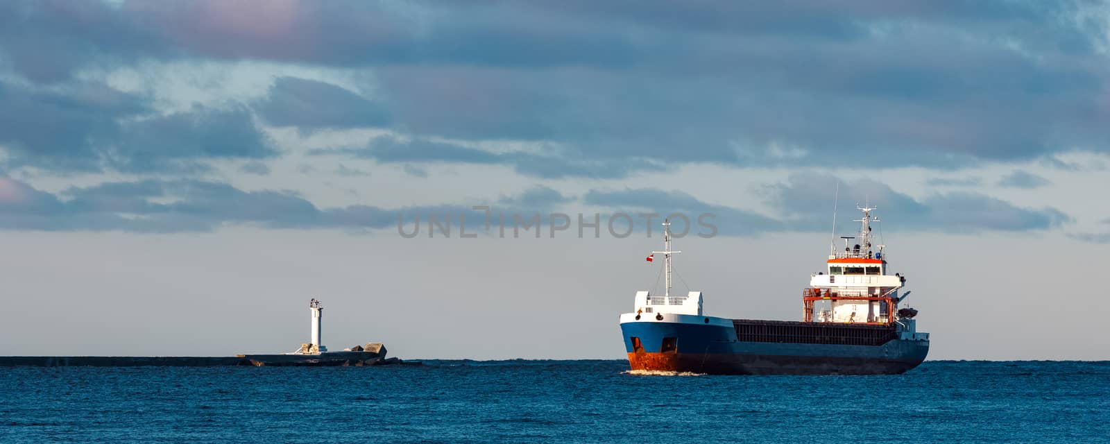 Blue bulk carrier sailing in still water