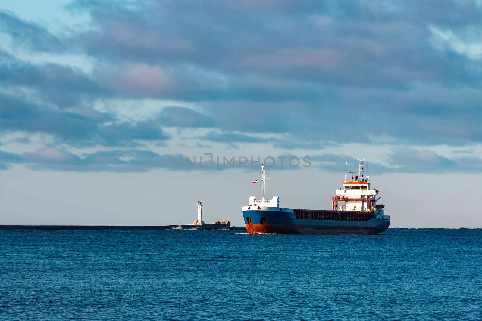 Blue bulk carrier sailing in still water