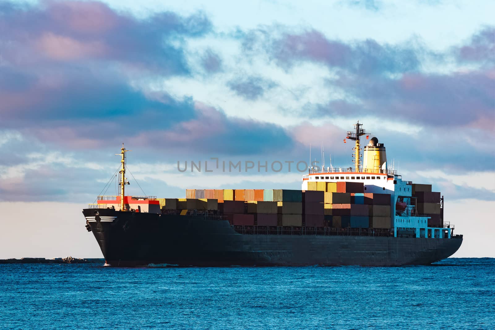 Modern black container ship moving from Baltic sea