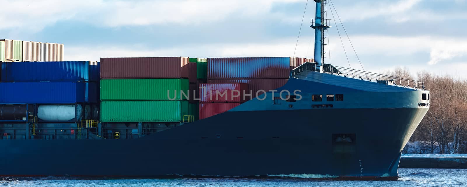 Modern grey container ship moving in still water